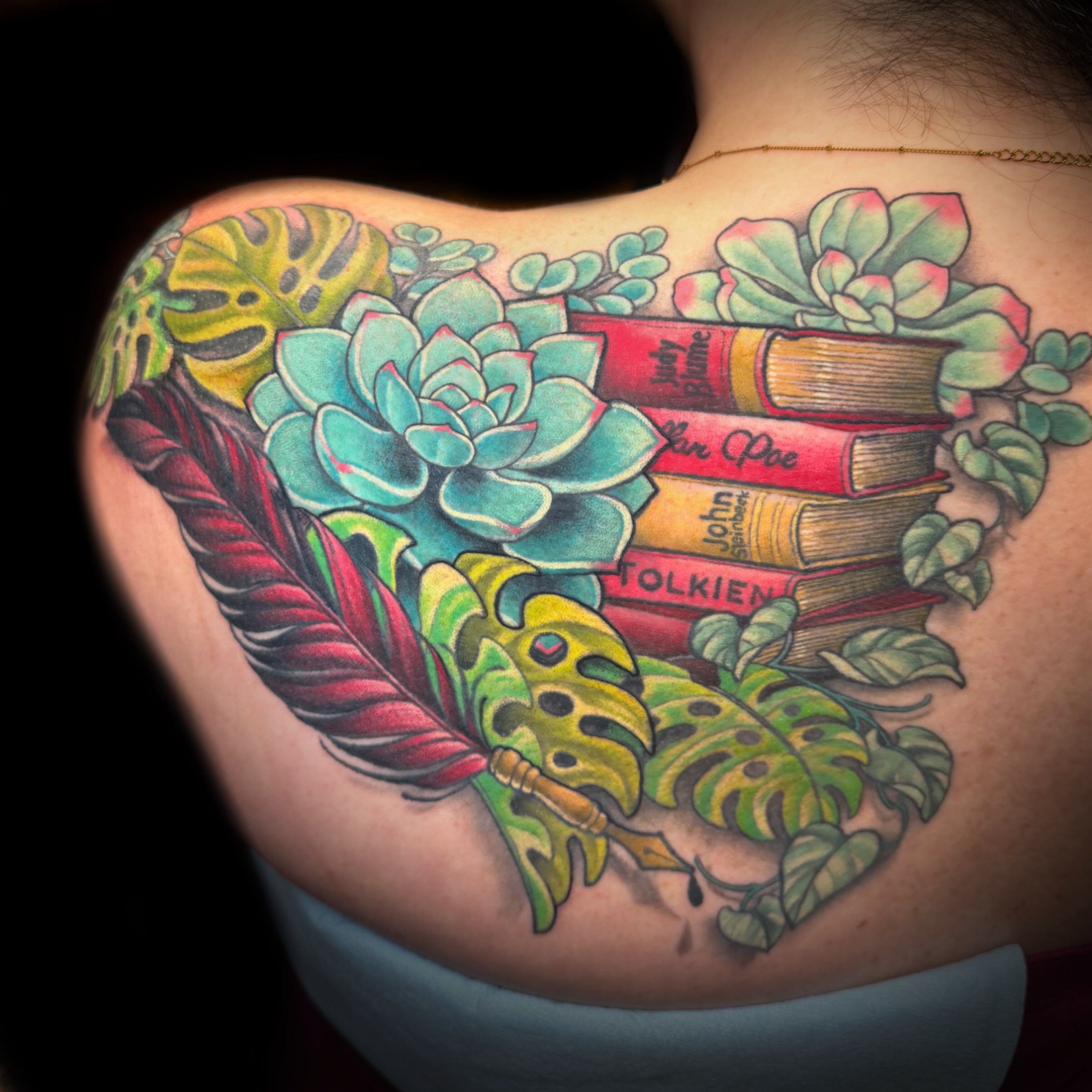 Books and succulents tattoo on the shoulder by Kelsea Weir McCree