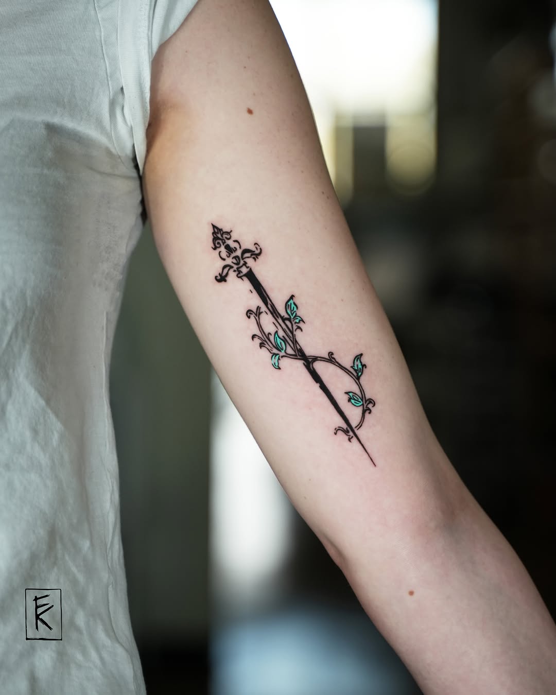 Arrow with floral design fine line tattoo on the forearm by elizaveta
