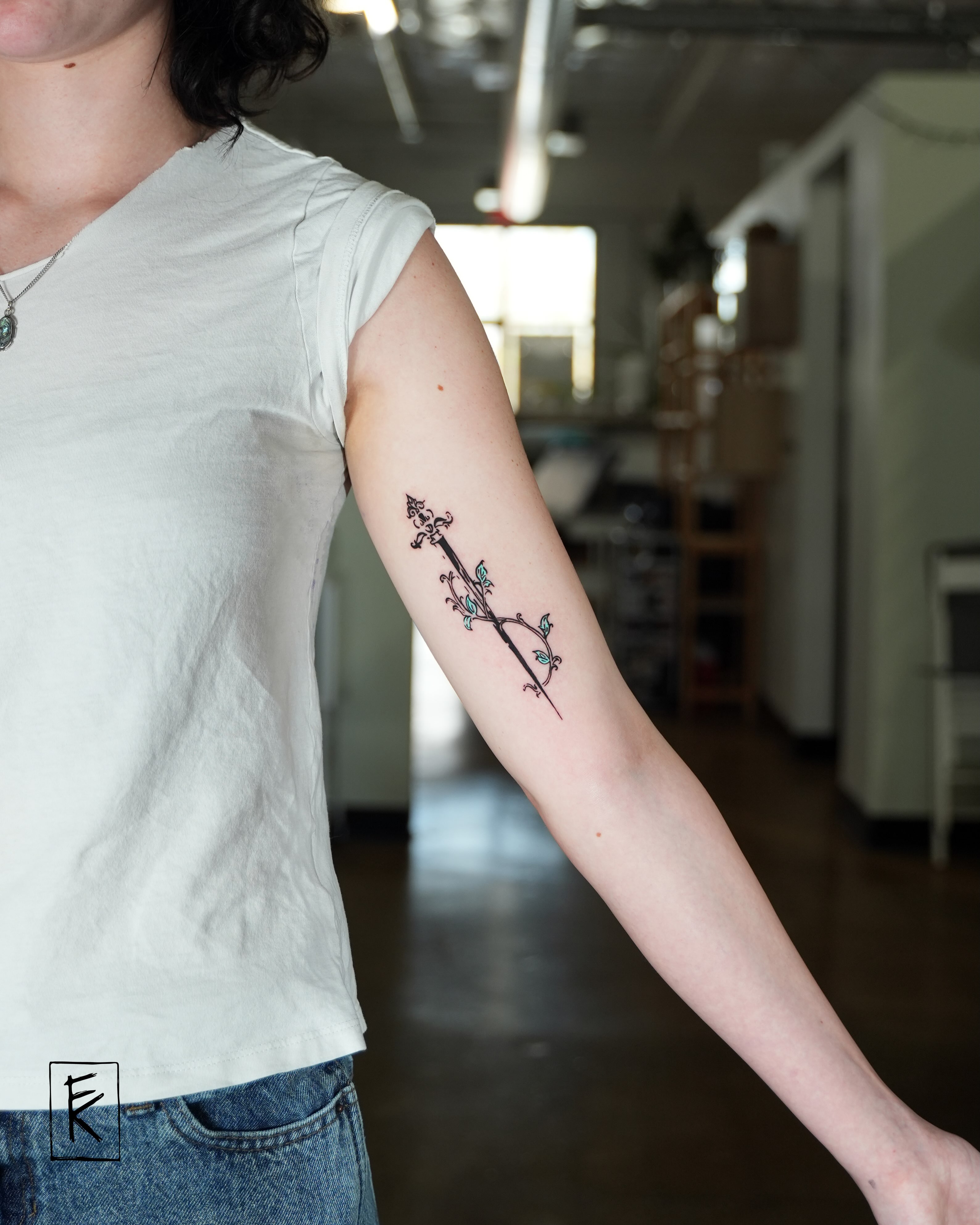 Arrow with floral details fine line tattoo on the forearm by elizaveta