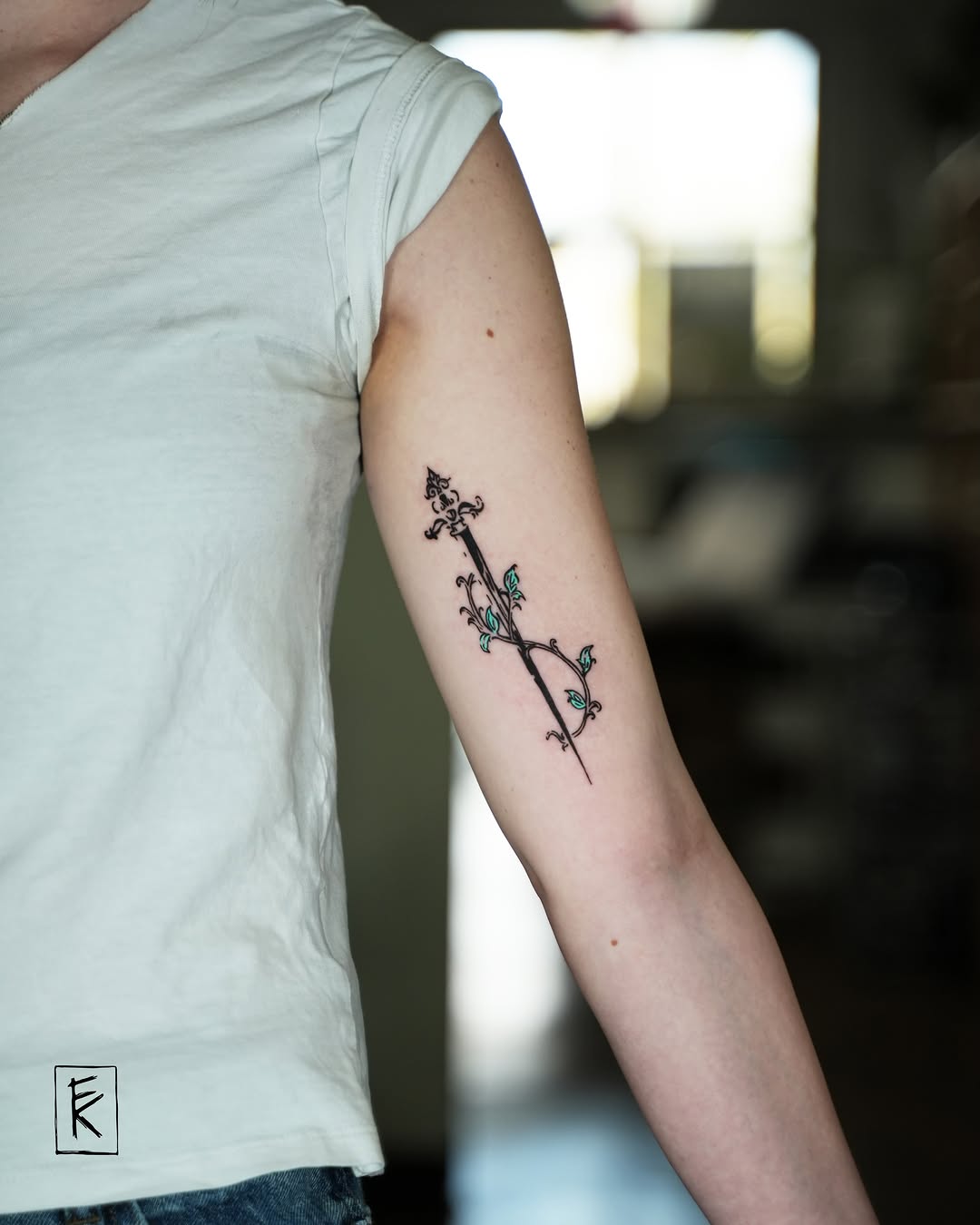 Flower and stem fine line tattoo on the forearm by elizaveta