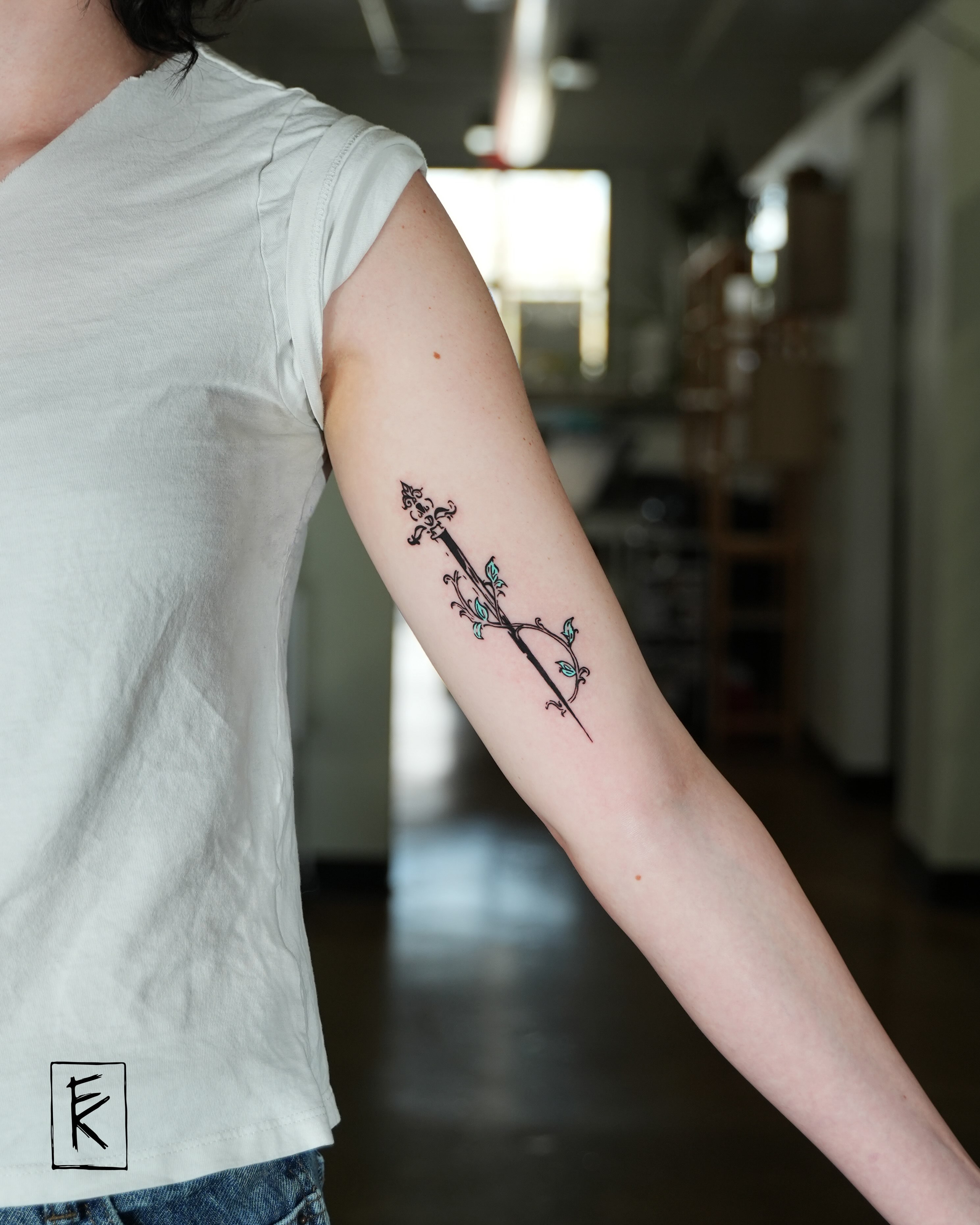 Arrow with floral details fine line tattoo on the forearm by elizaveta