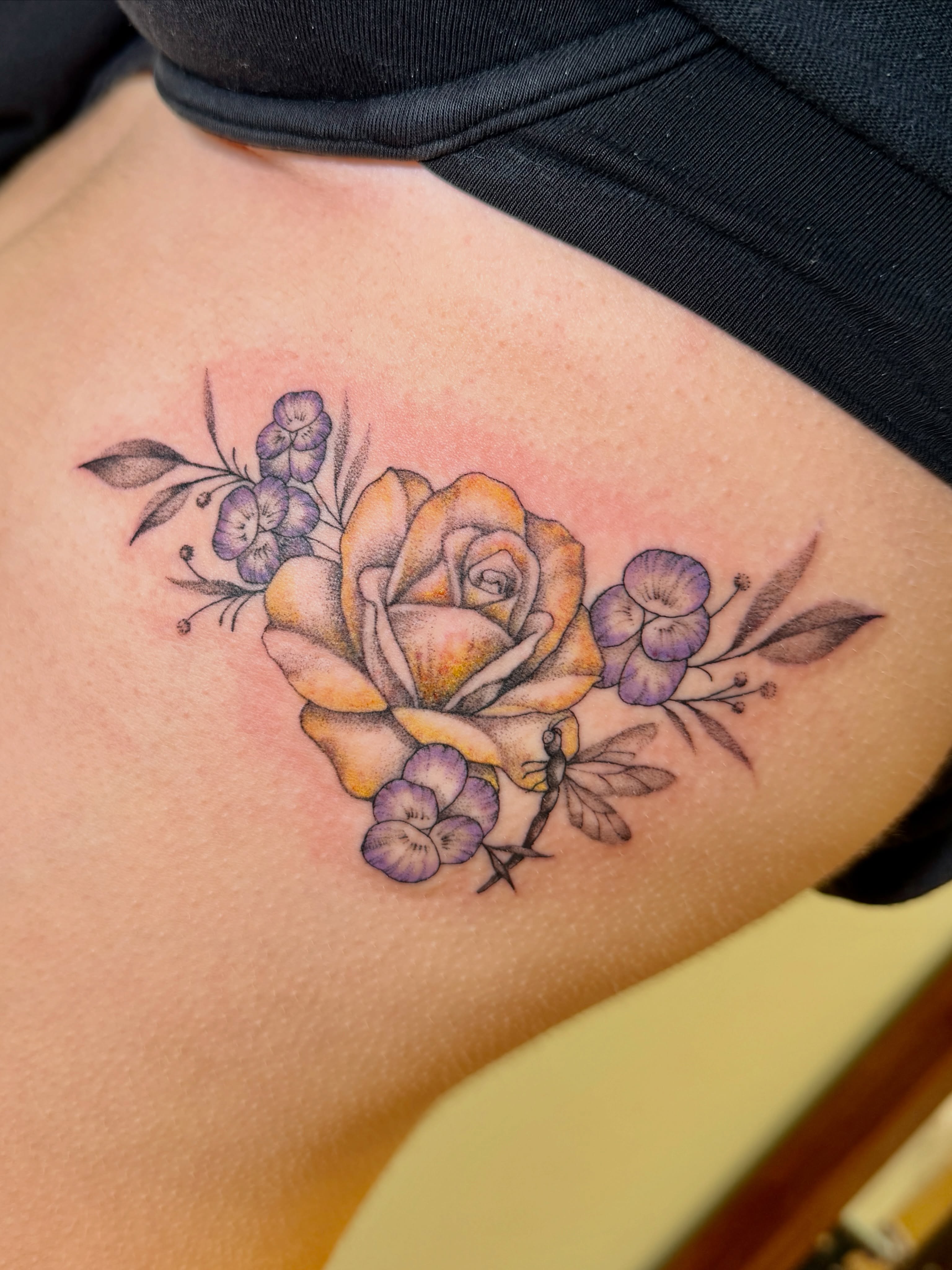 Yellow rose with purple flowers realism tattoo on the thigh by Koryn Donnelly
