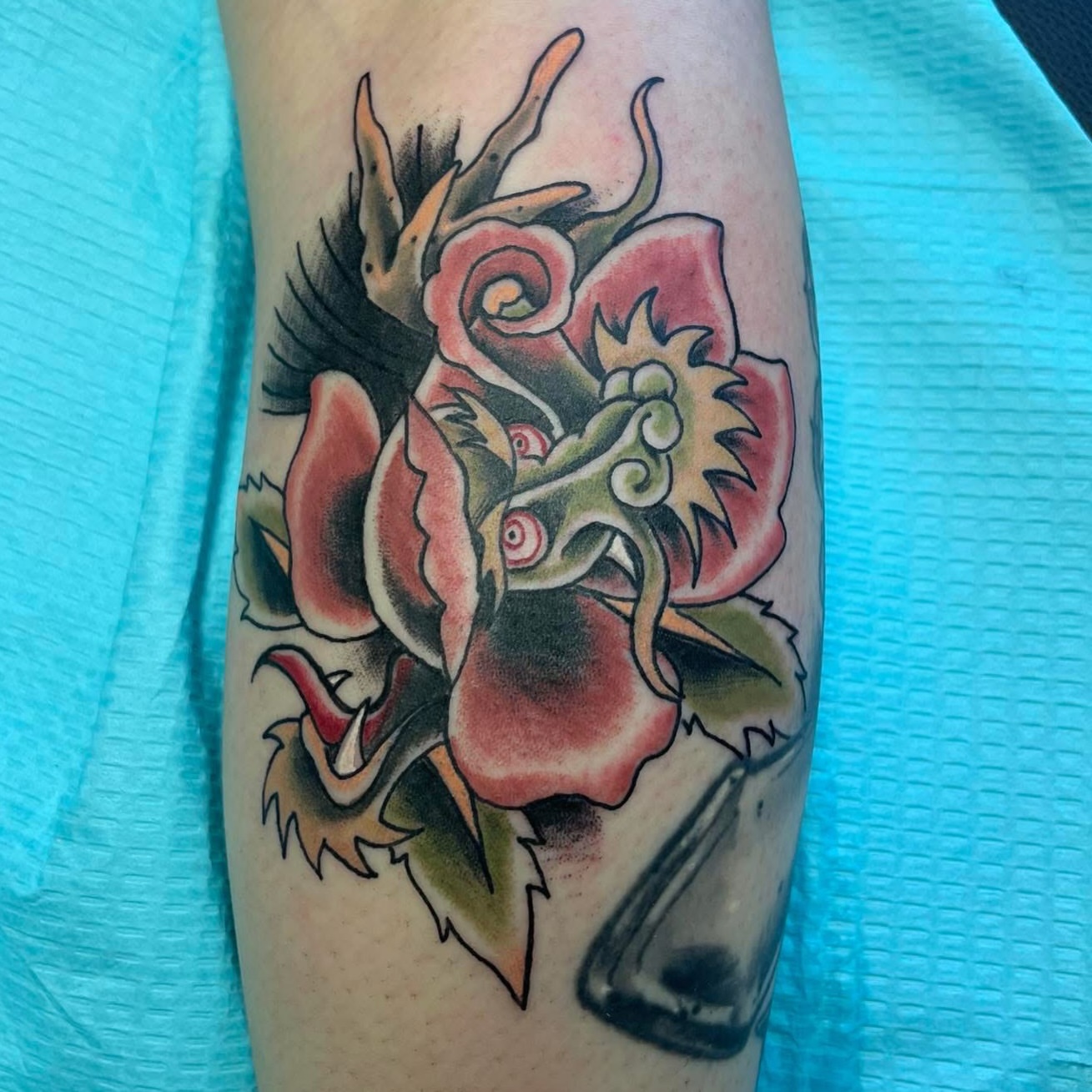 Rose with dragon American traditional tattoo on the forearm by Vudu Tattooer