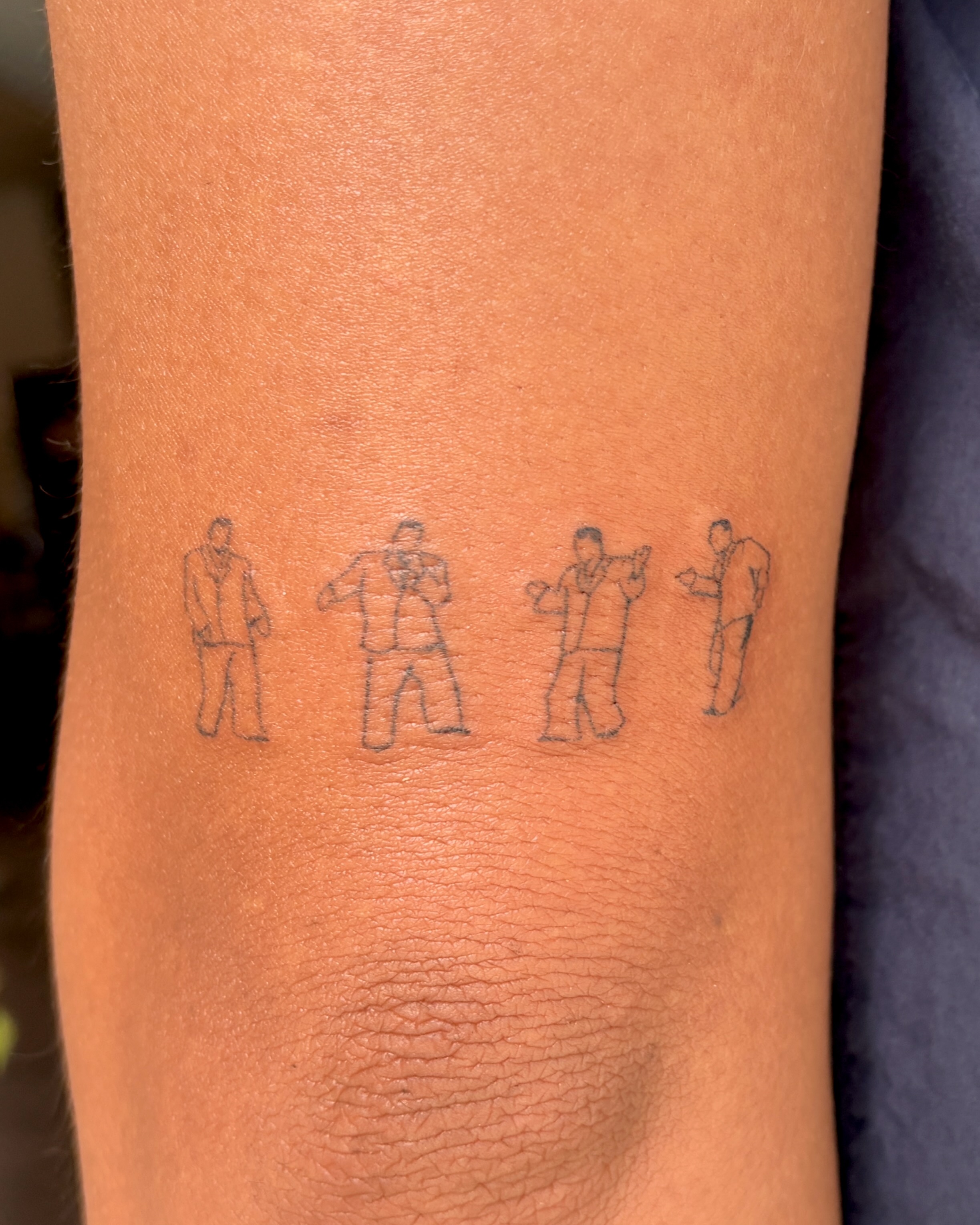 Four men dancing black and grey tattoo on the forearm by alli ミ☆
