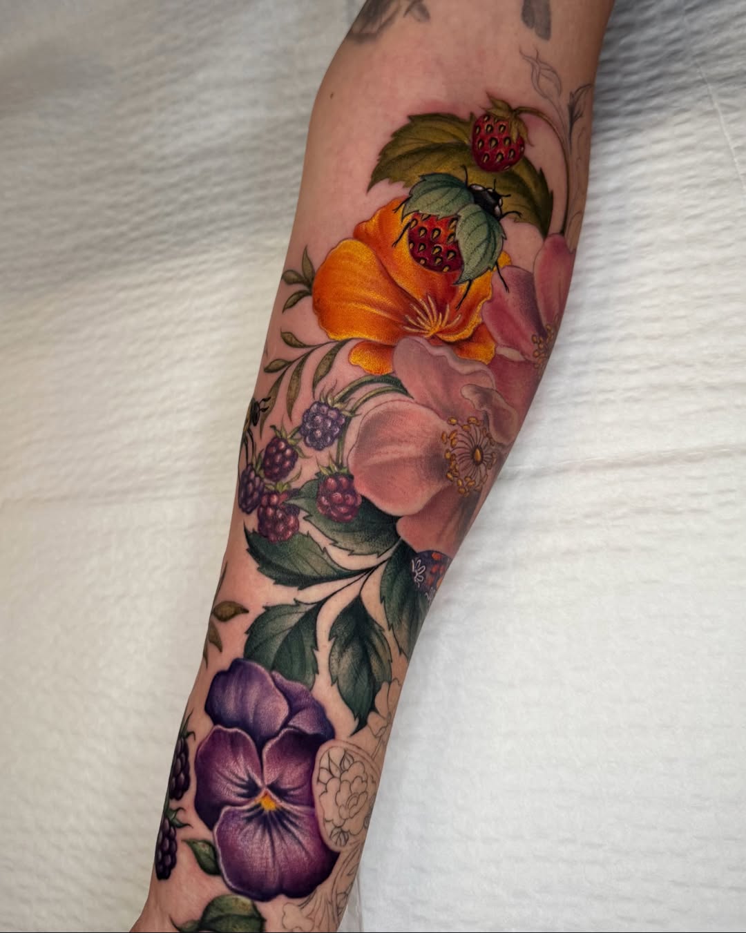 Floral arrangement realism tattoo on the forearm by Nichole Lorence