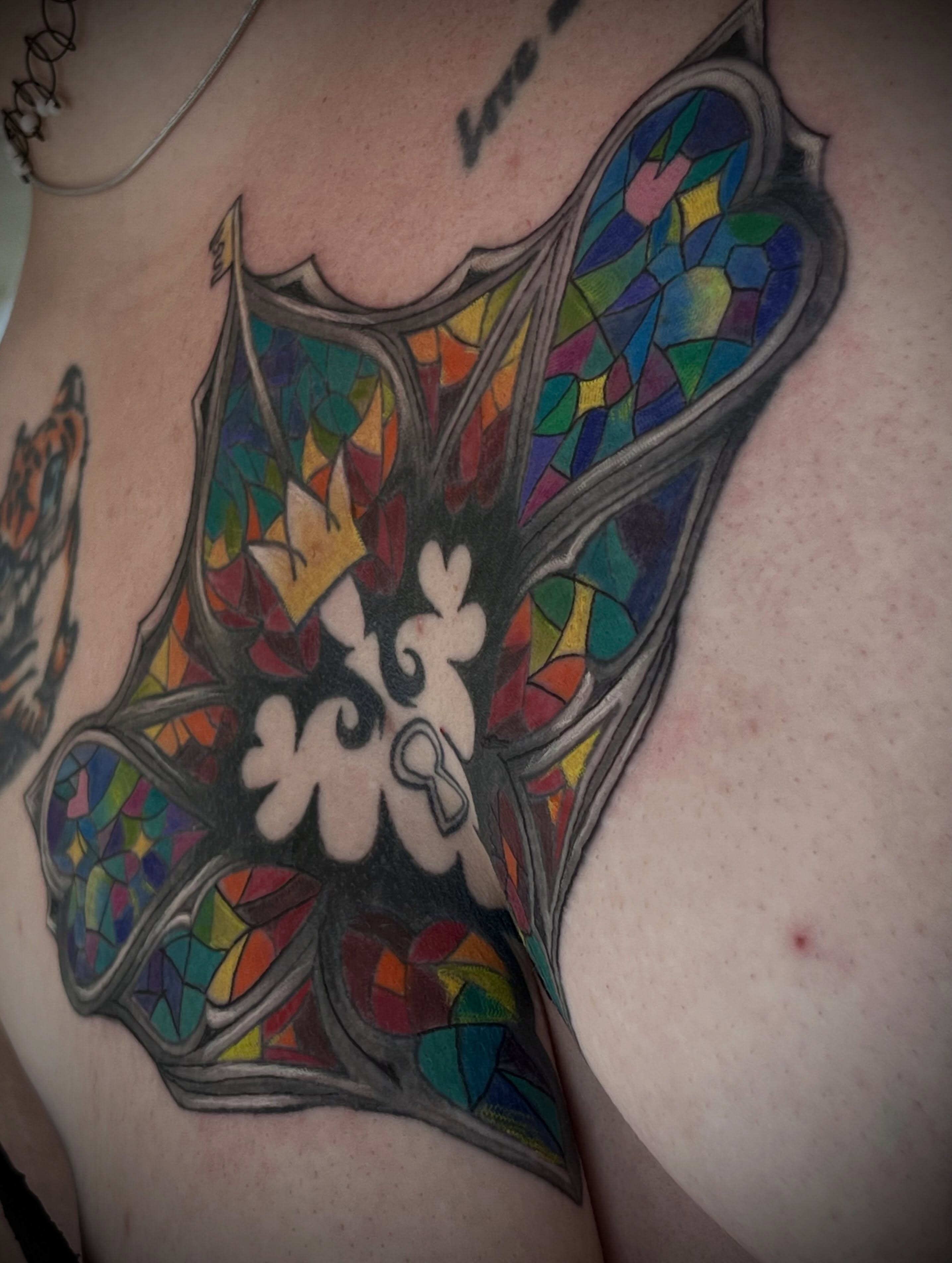 Stained glass window geometric tattoo on the chest by Freya Petersen