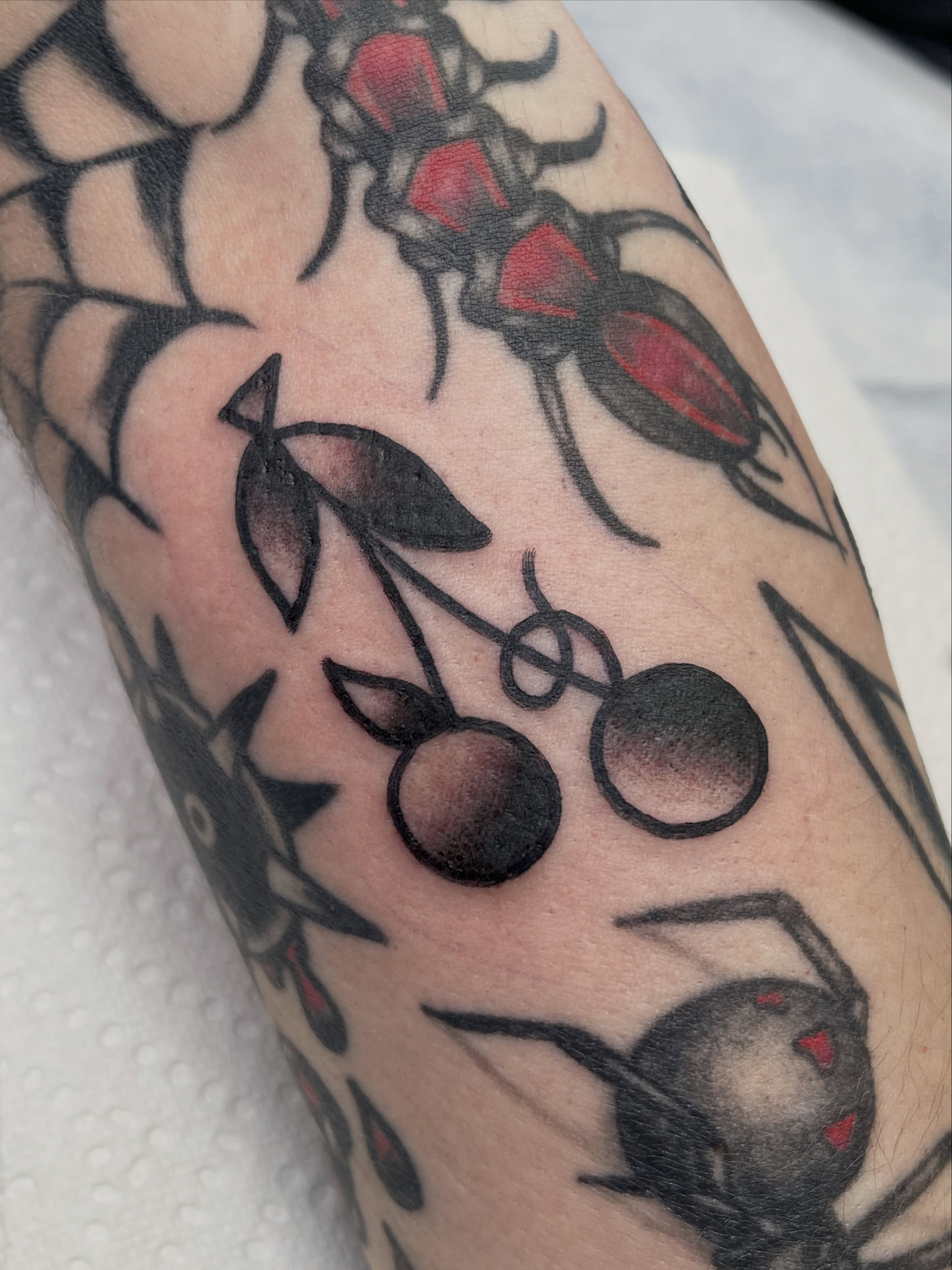 Cherries American traditional tattoo on the forearm by Chris Martin