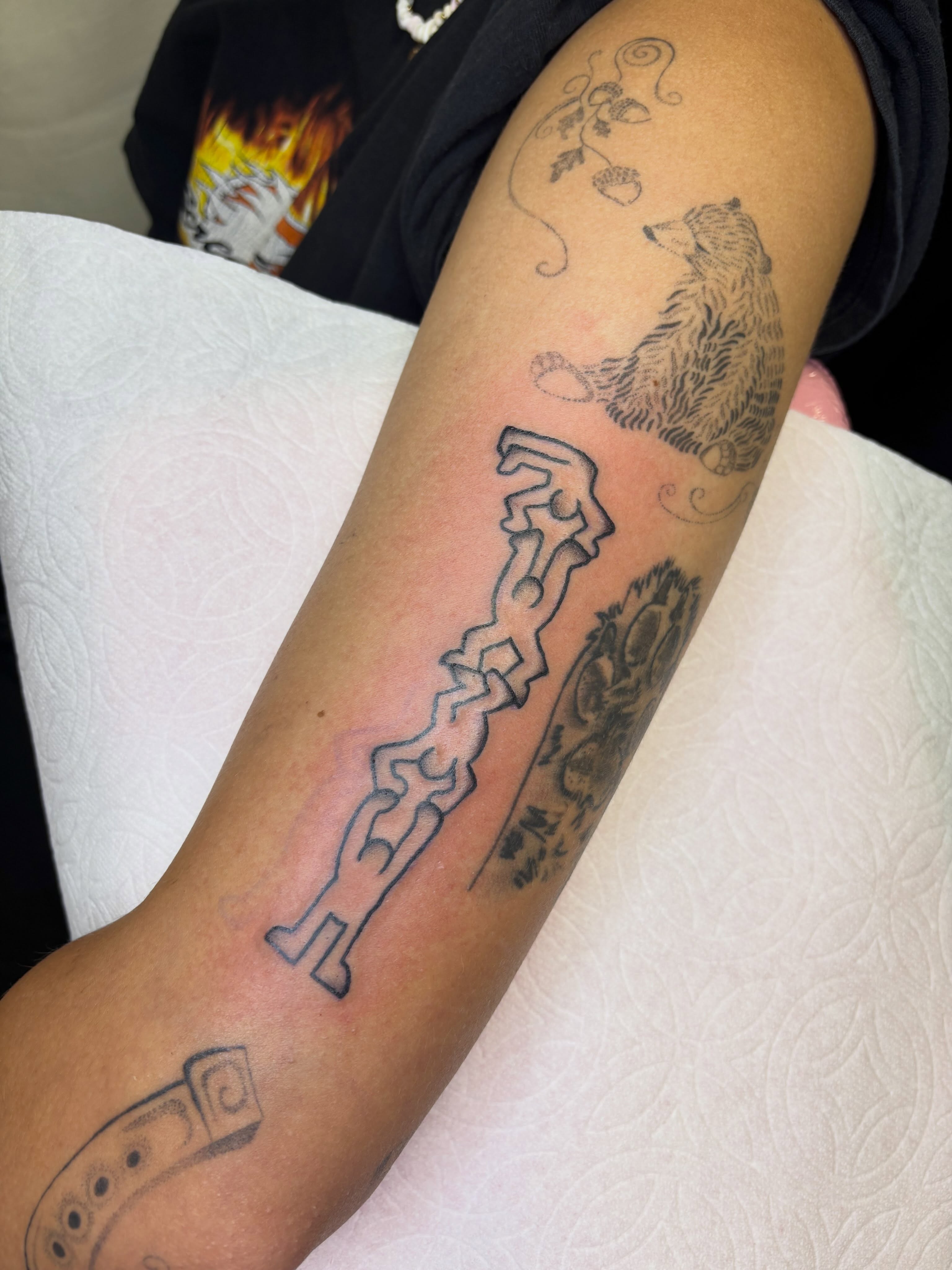 Bear and key black and grey tattoo on the forearm by Topher Belmont