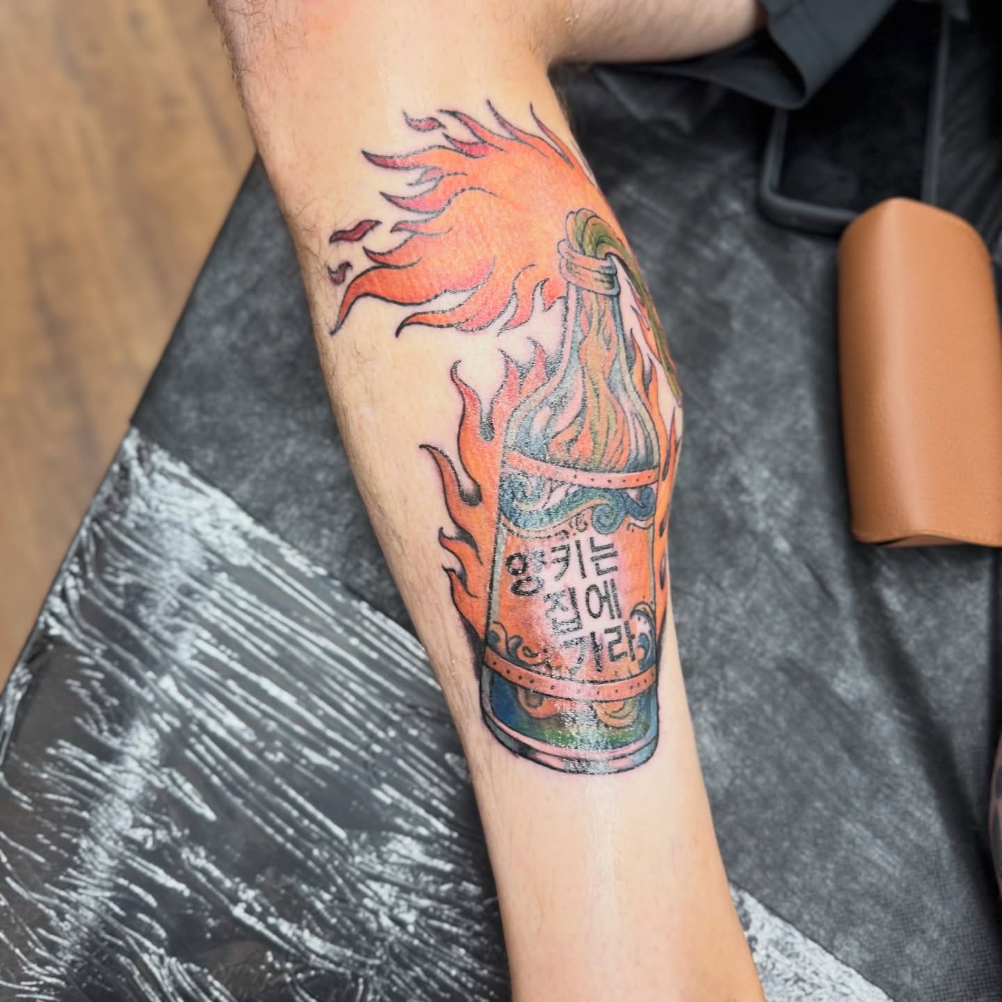 Flaming bottle American traditional tattoo on the forearm by Chuckthegirl