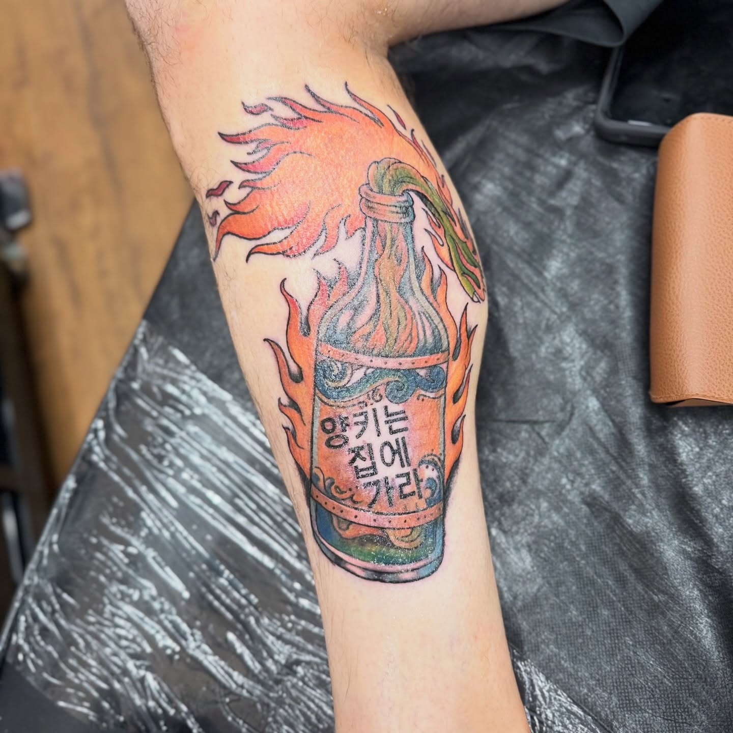 Flaming bottle American traditional tattoo on the forearm by Chuckthegirl