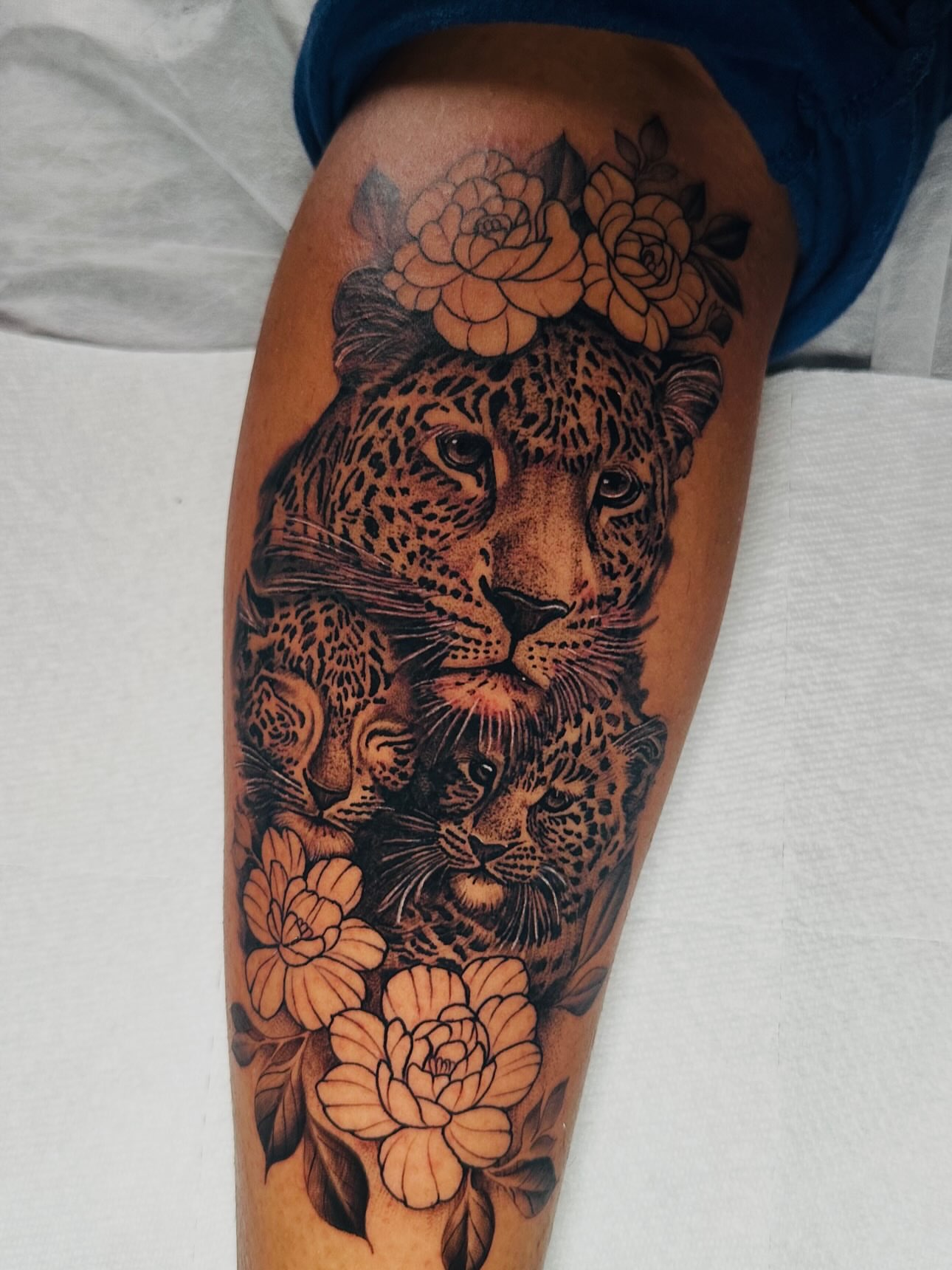 Leopard and flowers realism tattoo on the thigh by ⠀Joey Rosado
