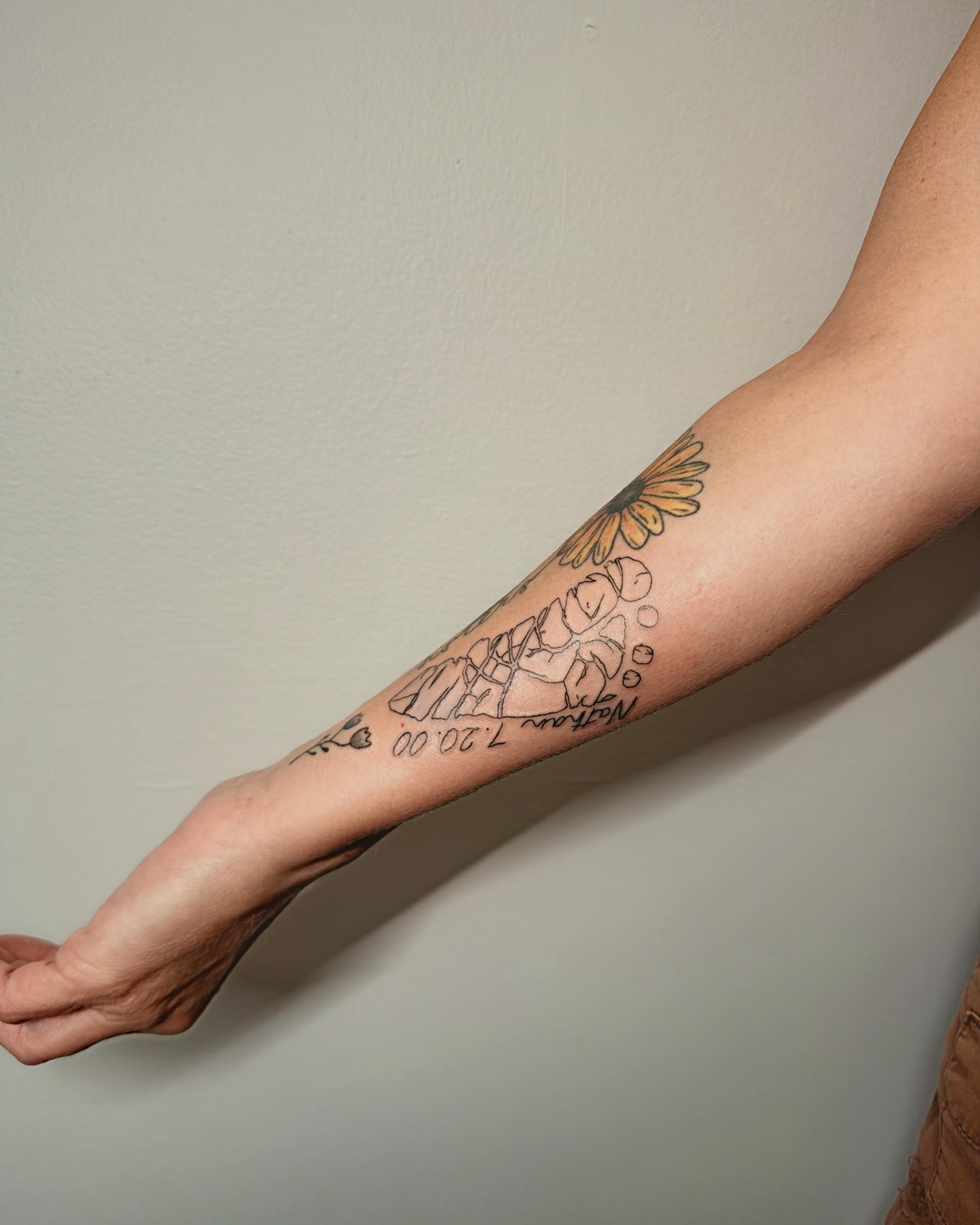 Flower and child black and grey tattoo on the forearm by Ashlee Burkey