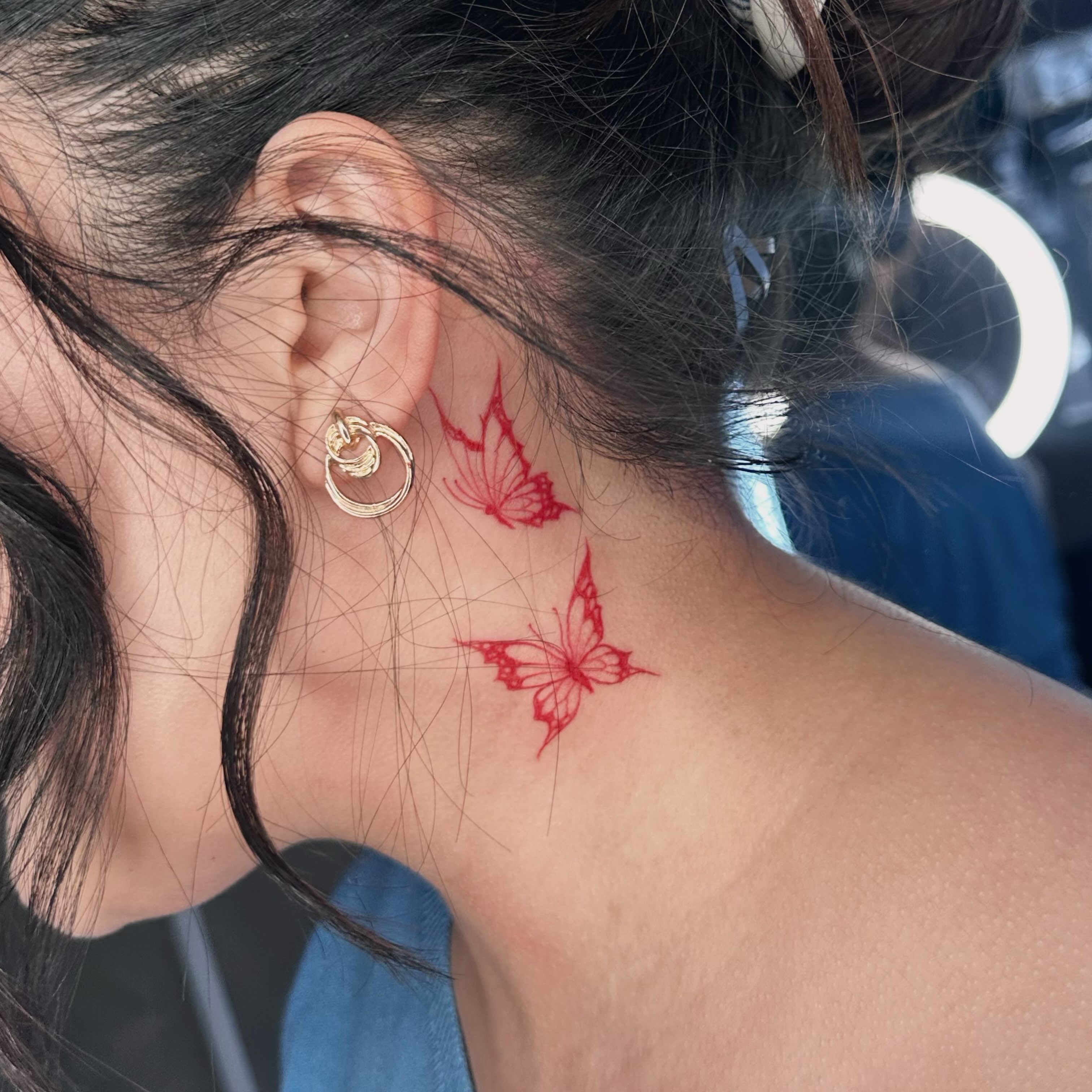 Butterfly geometric tattoo on the neck by Liv