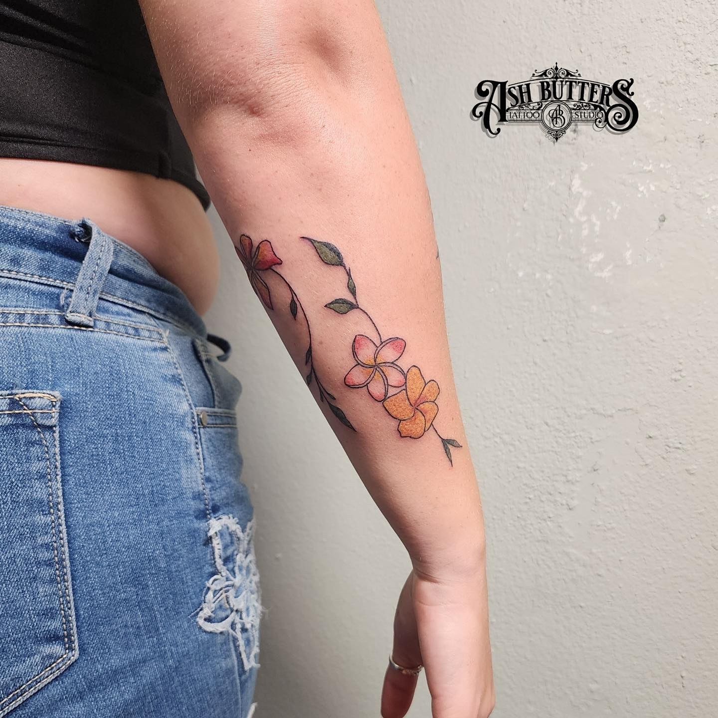 Flowers watercolor tattoo on the forearm by Ash Butters