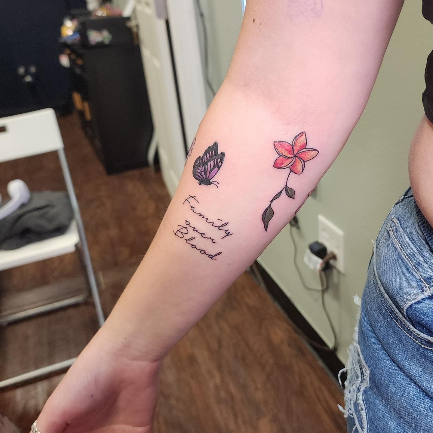 Flower and butterfly new school tattoo on the forearm by Ash Butters