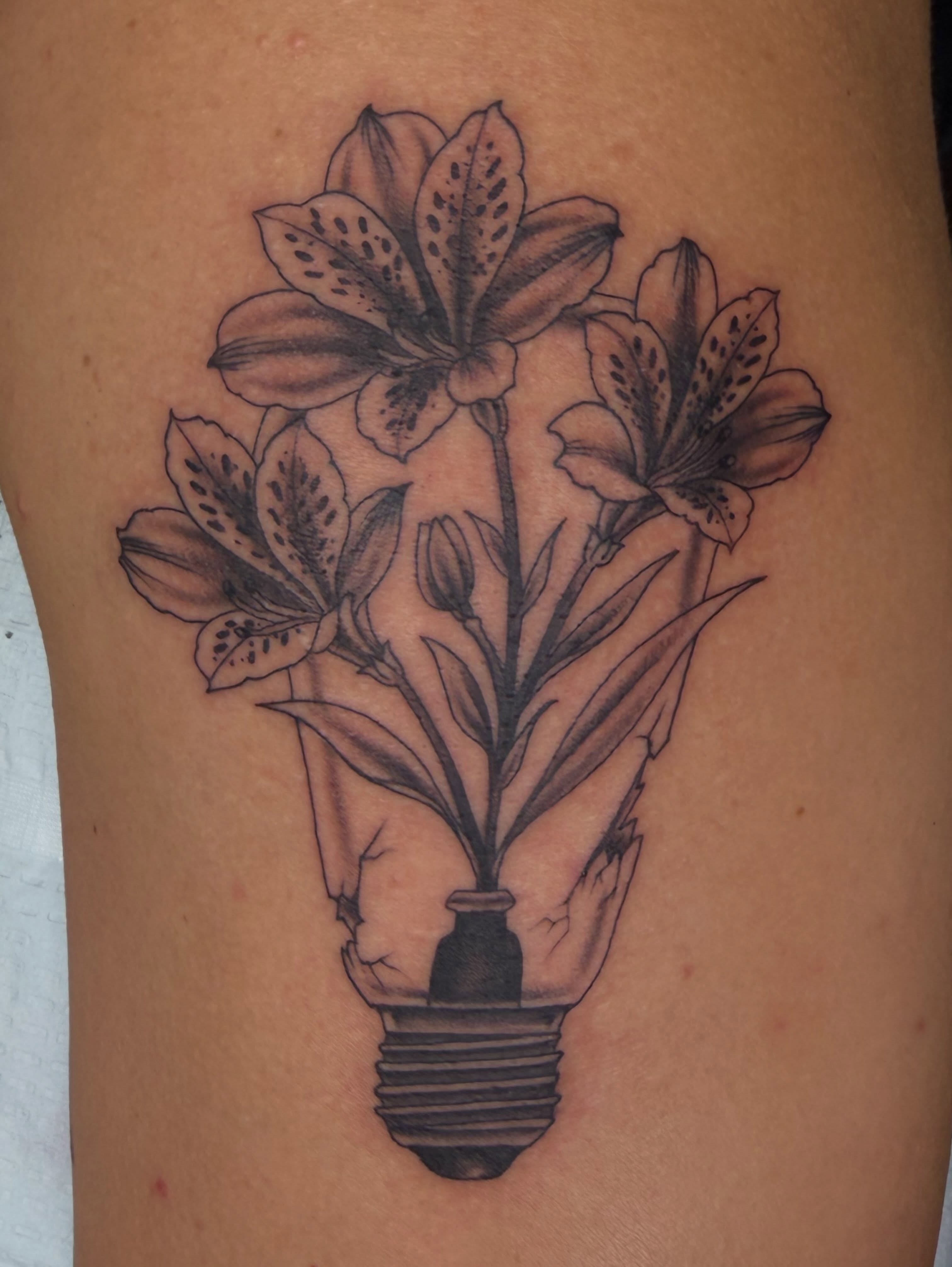 Flower bouquet black and grey tattoo on the thigh by Thomas Cook