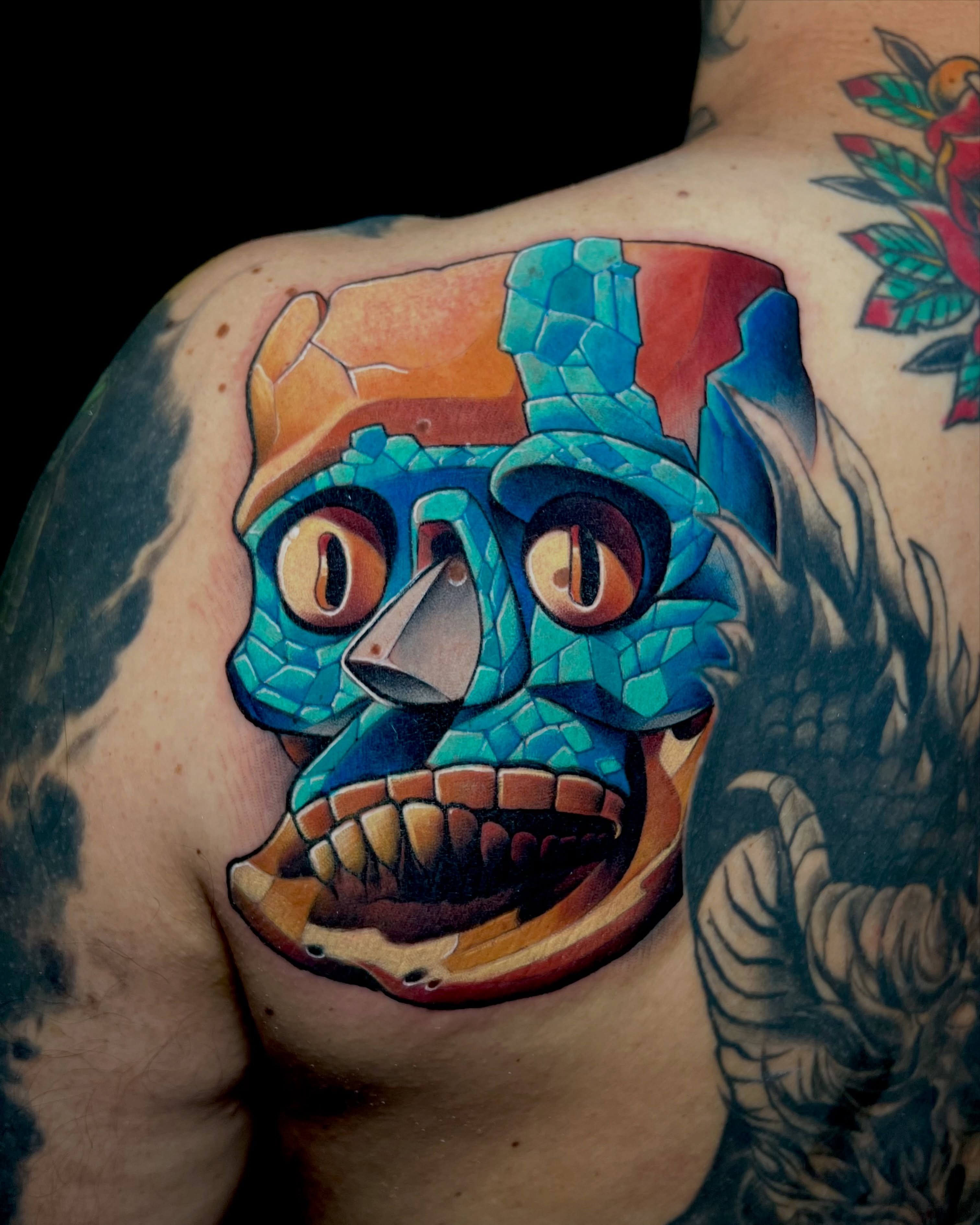 Mask neo-traditional tattoo on the shoulder by Meza Cruz