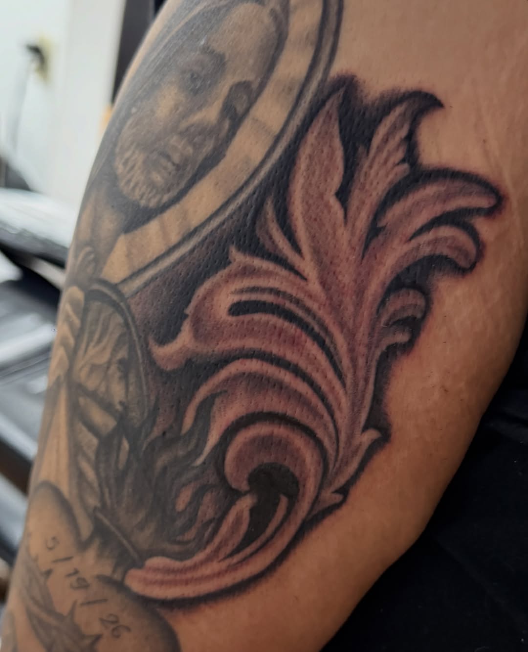 Floral wave black and grey tattoo on the upper arm by Royal Martinez
