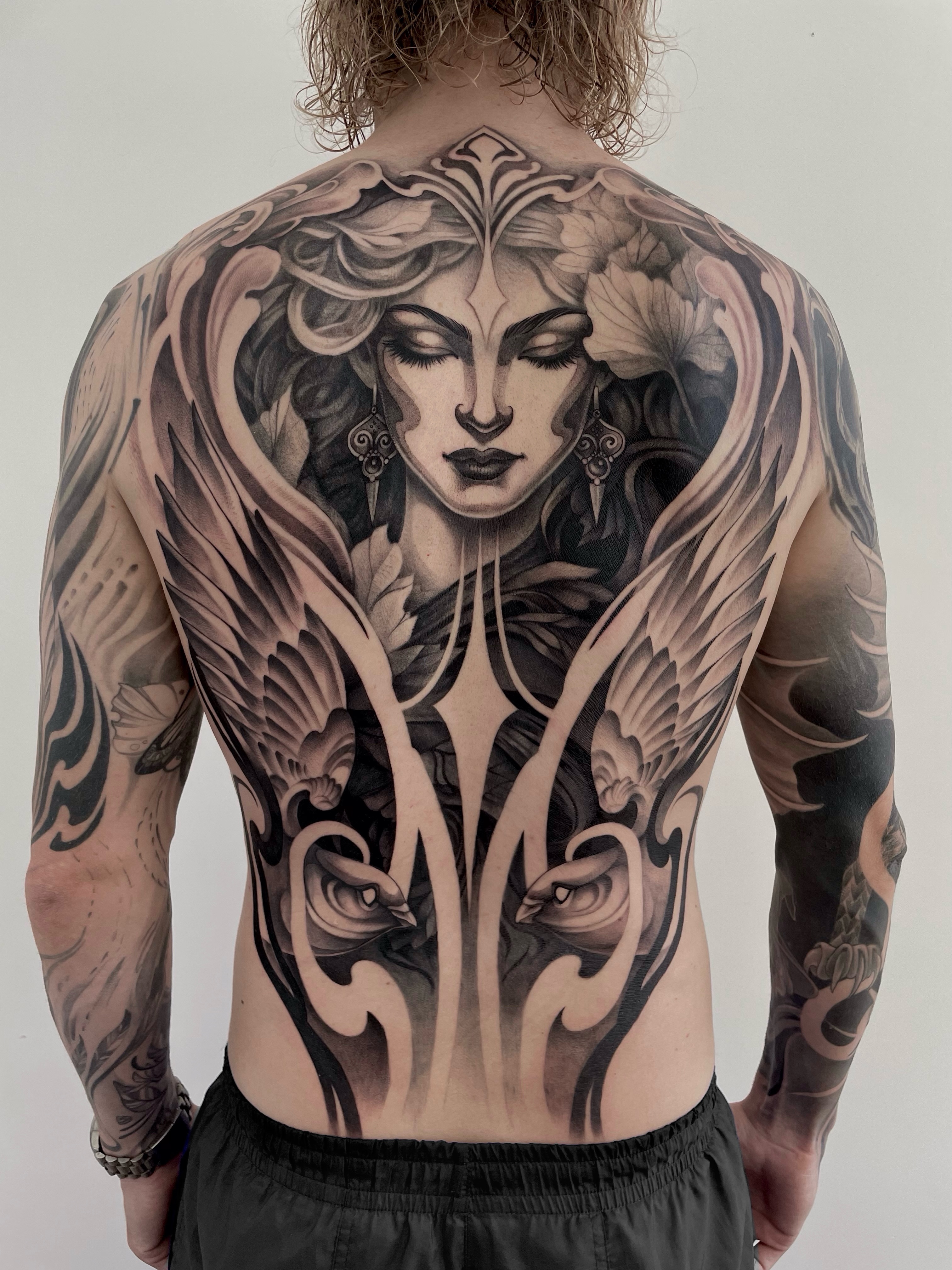 Woman with wings realism tattoo on the back by Michelle Carlton
