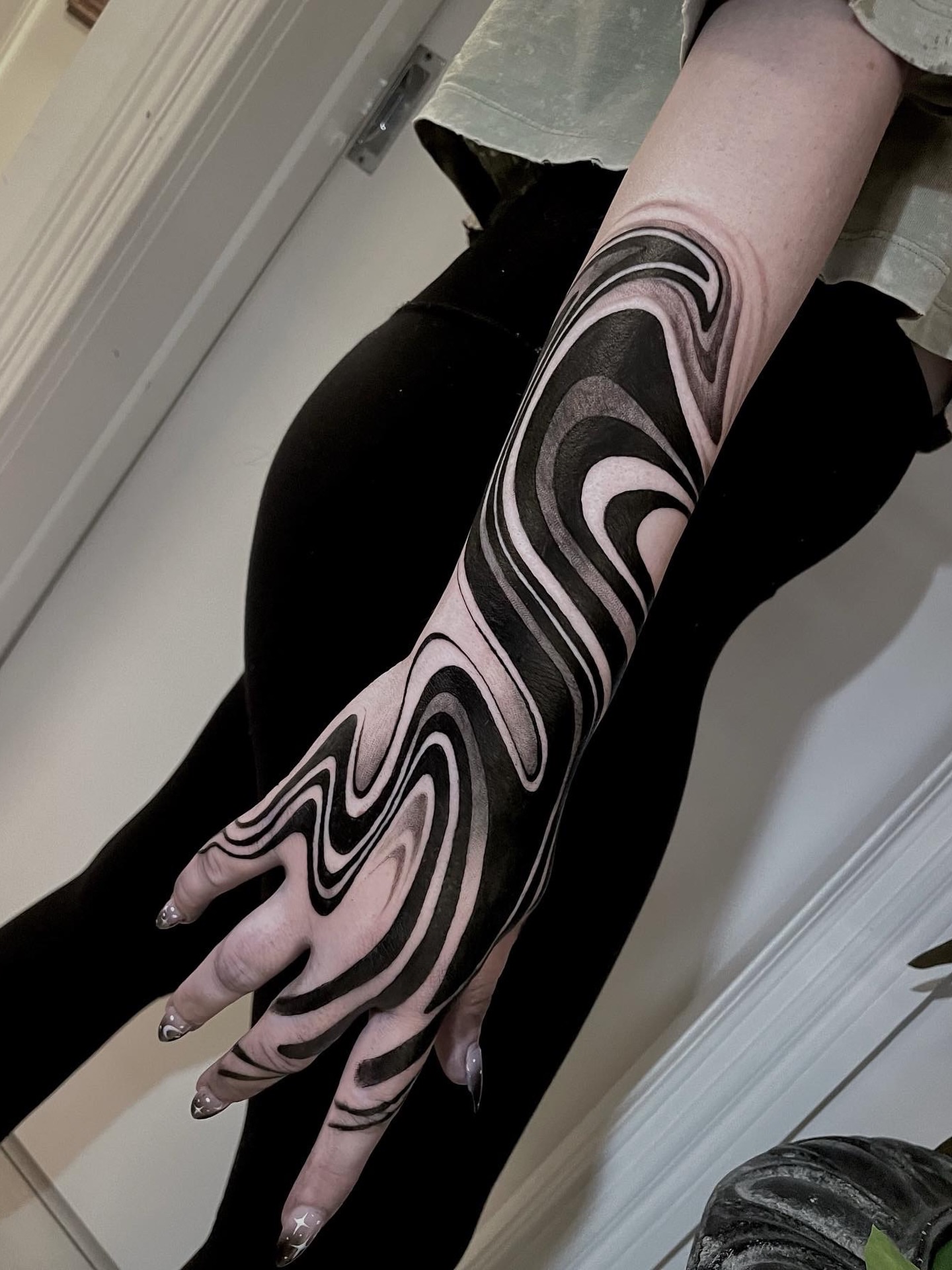 Wave pattern black and grey tattoo on the upper arm by Michelle Carlton
