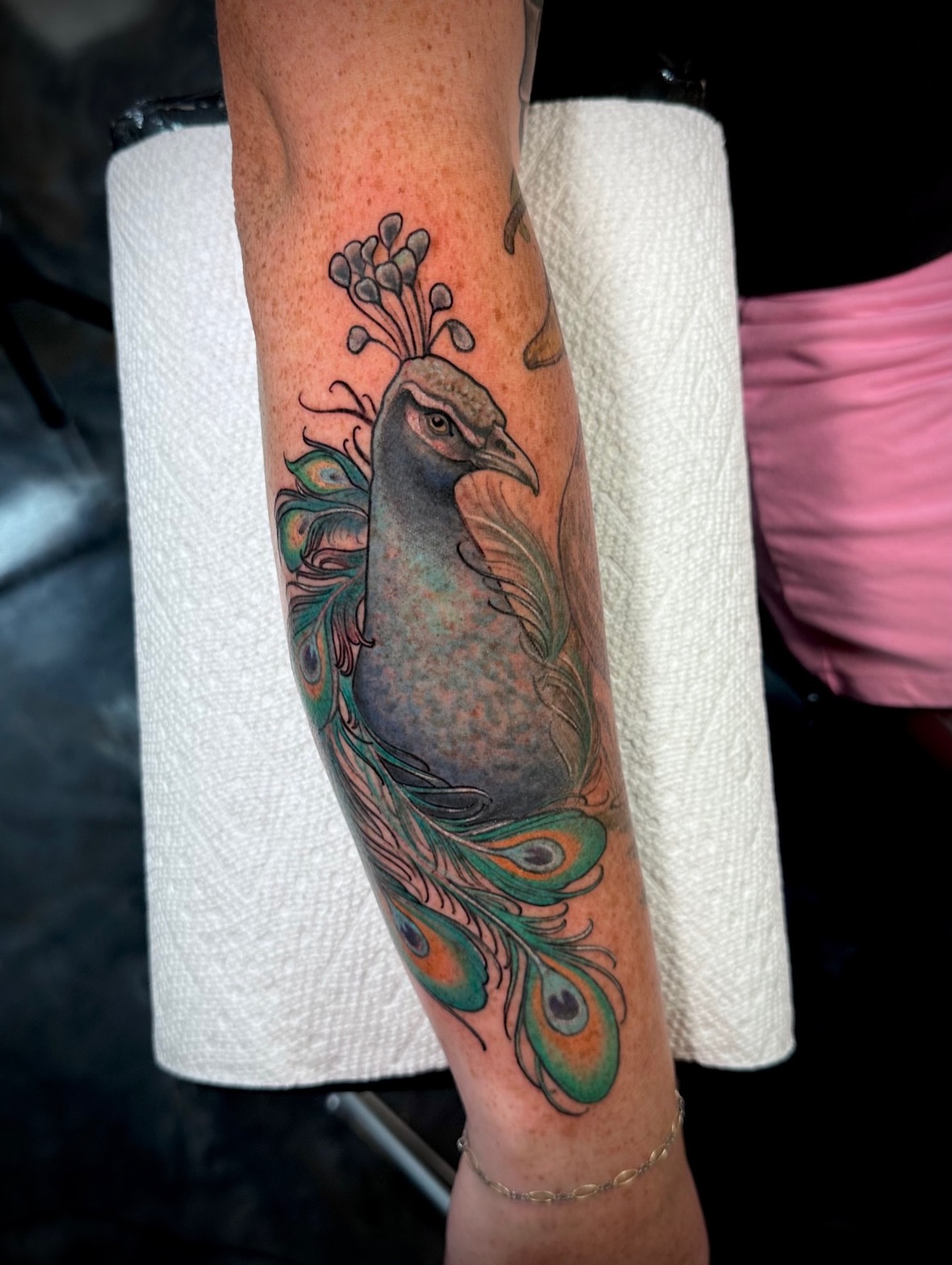 Peacock realism tattoo on the forearm by Teddi Garson