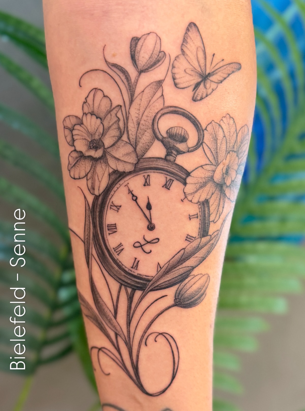 Clock and flowers realism tattoo on the forearm by Die Ivo, Bielefeld, Germany