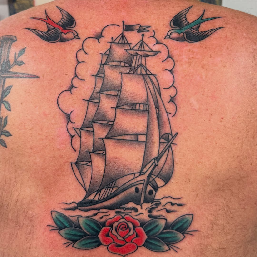 Sailboat and rose American traditional tattoo on the back by Jason Eisenberg