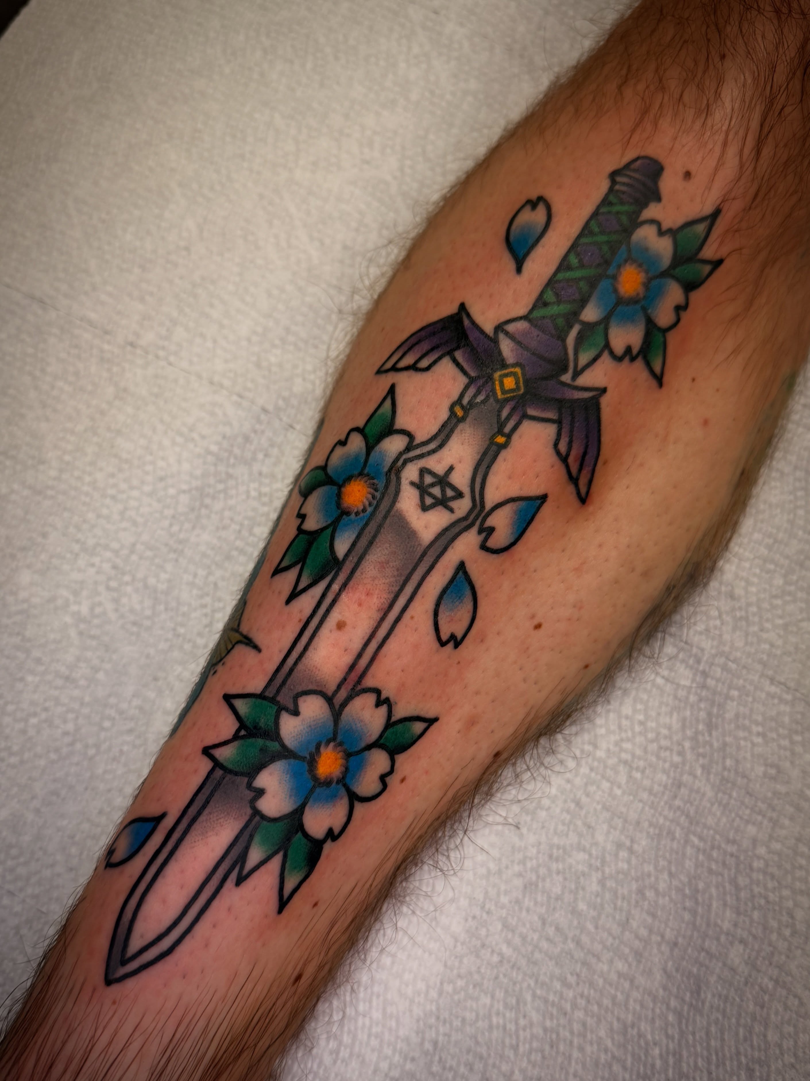Sword and flowers American traditional tattoo on the forearm by Dave Osrowitz