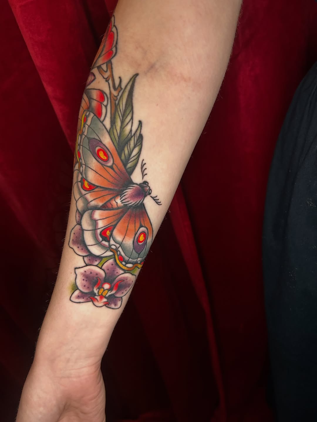 Moth and orchid neo-traditional tattoo on the forearm by Olivia Marie