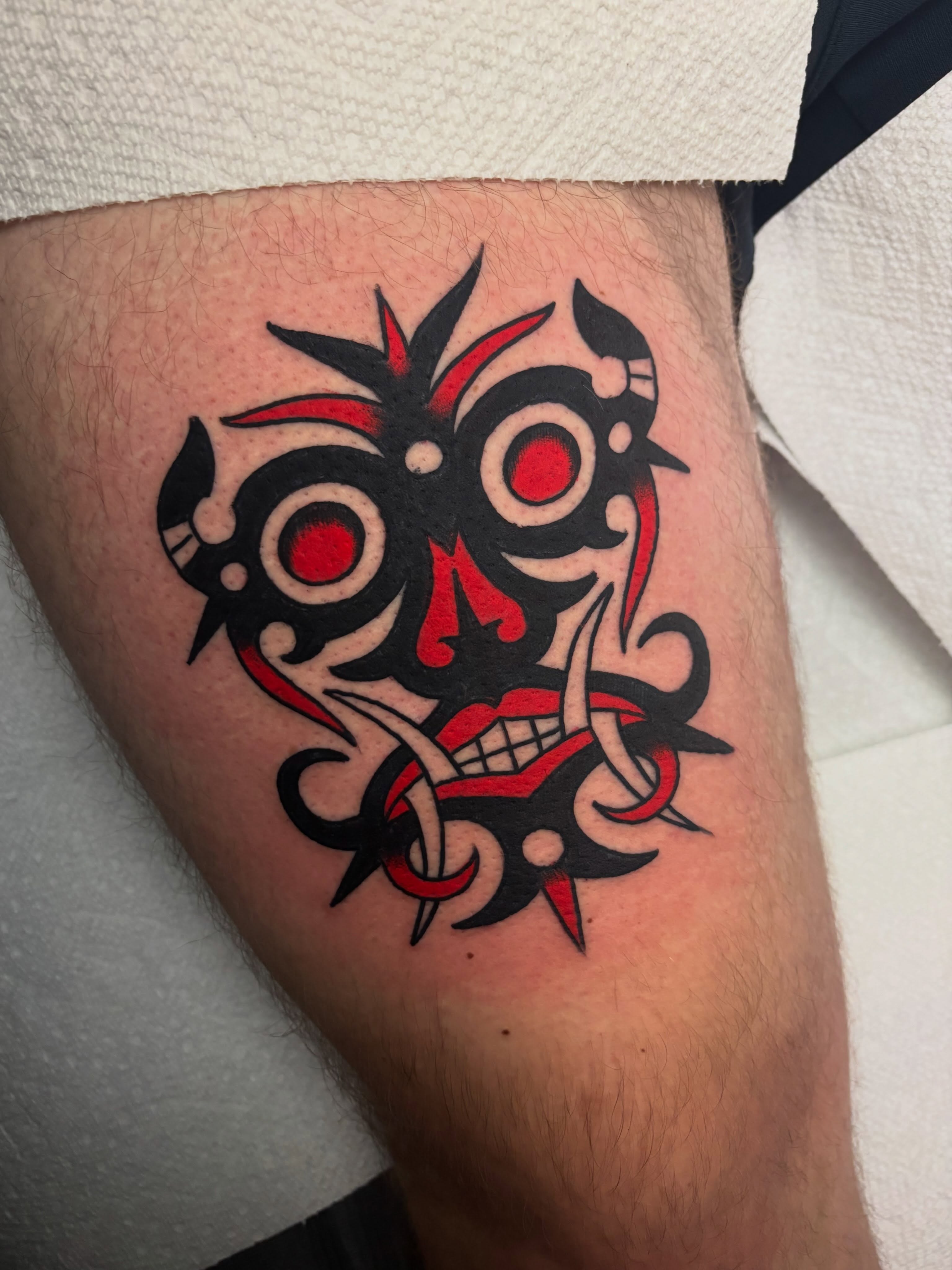 Skull tribal tattoo on the thigh by Chris Dufresne
