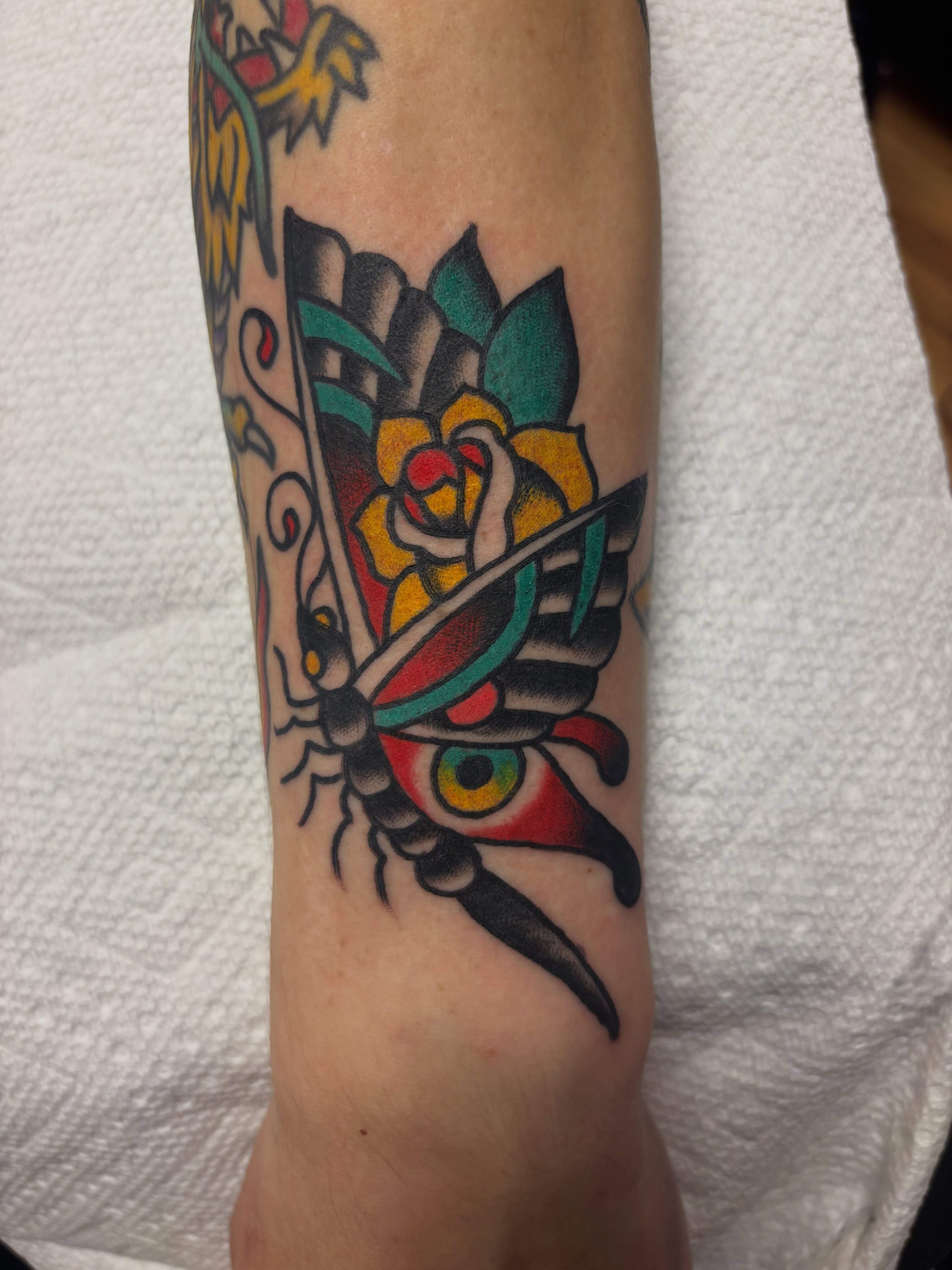 Butterfly and flower American traditional tattoo on the forearm by Chris Dufresne