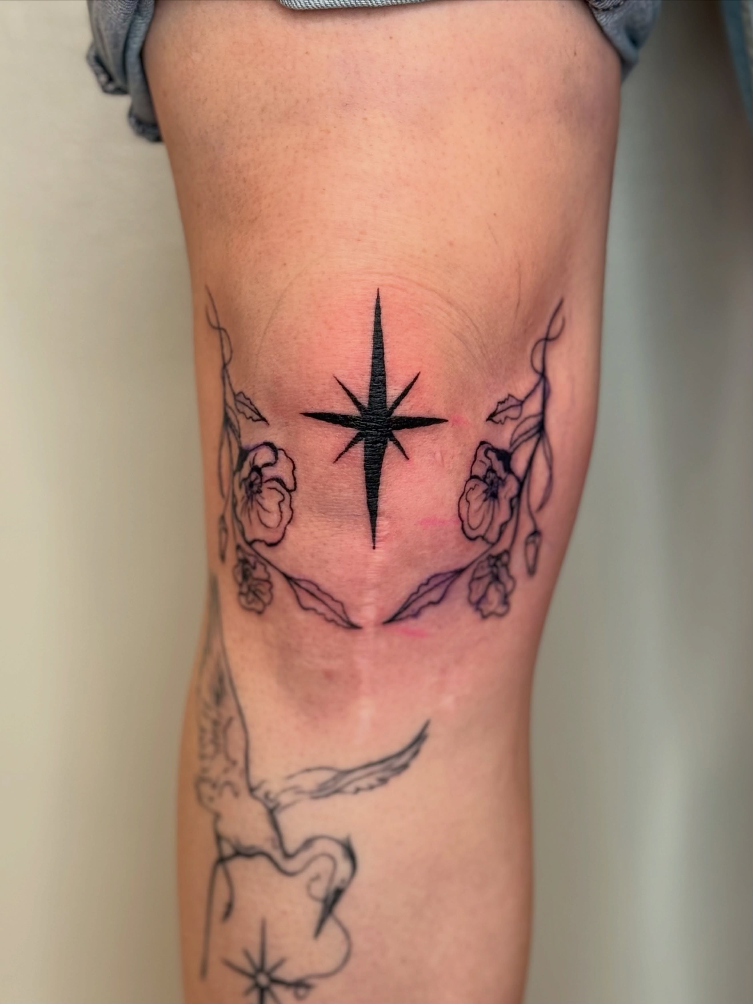 Star and floral black and grey tattoo on the forearm by Sarah