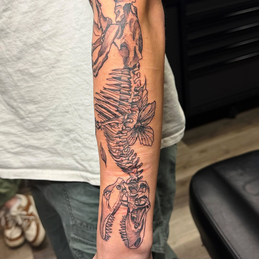 Dinosaur skeleton realism tattoo on the forearm by Emily