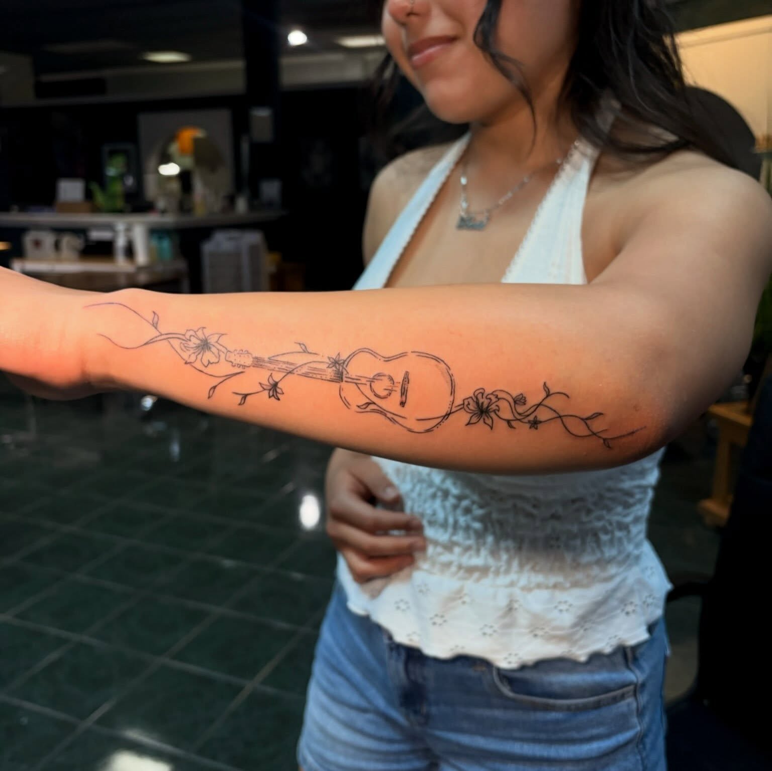 Ukulele and floral vine black and grey tattoo on the forearm by tati 🇬🇺🇵🇭
