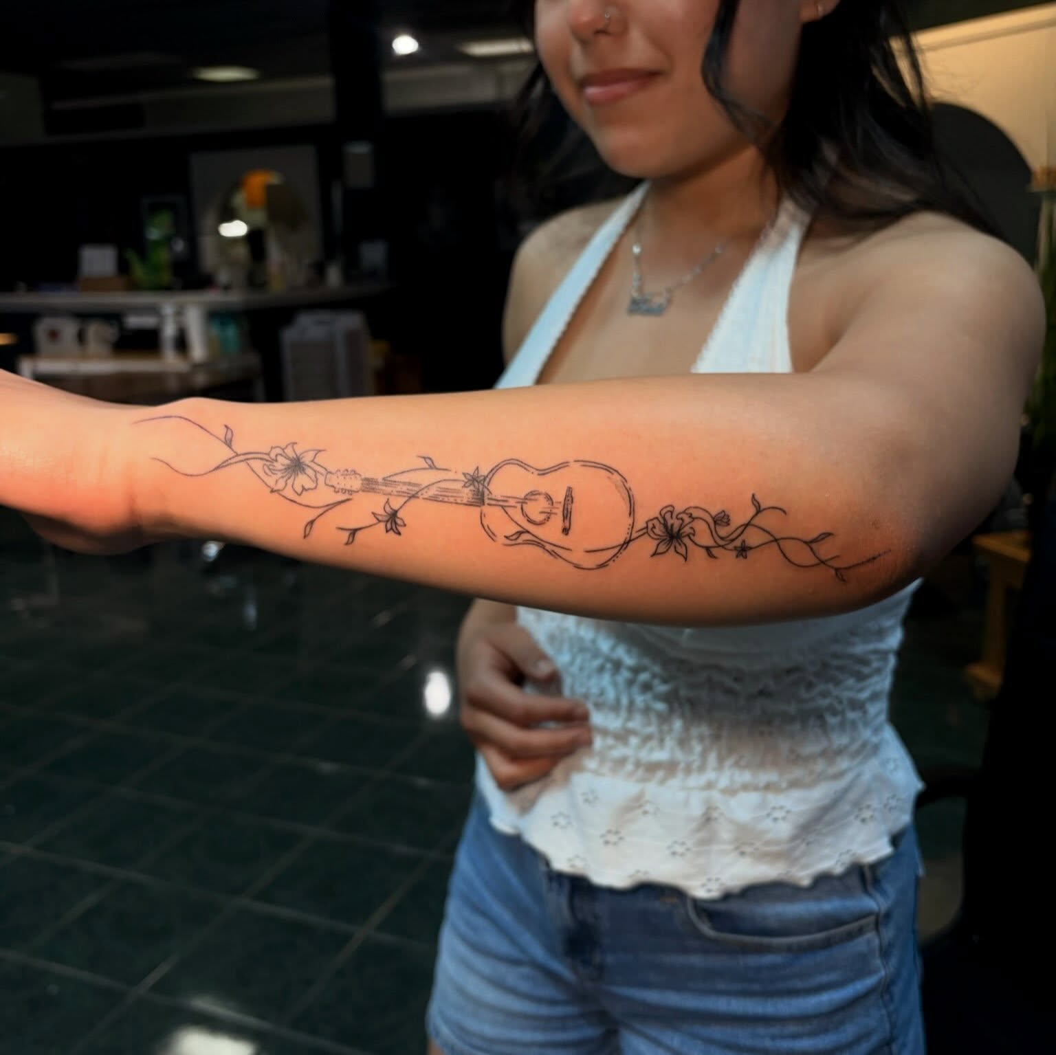 Guitar and floral vine black and grey tattoo on the forearm by tati 🇬🇺🇵🇭