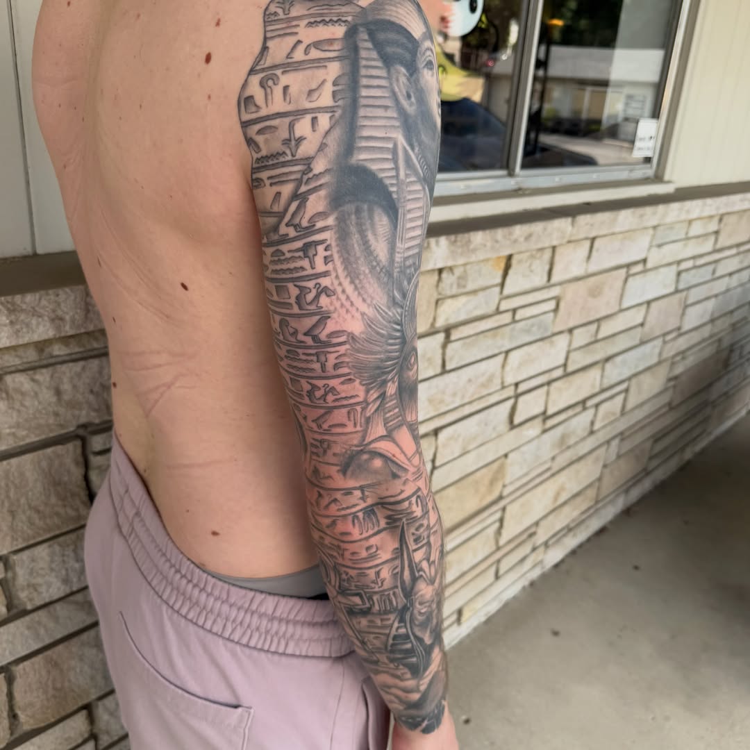 Pharaoh and hieroglyphics black and grey tattoo on the upper arm by Matthew Gordon