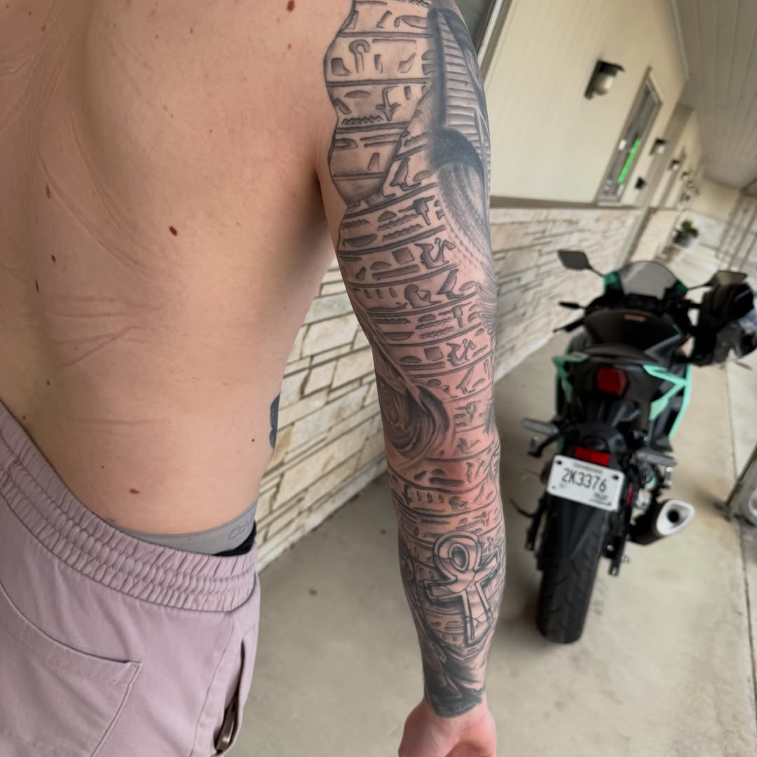 Ancient symbols black and grey tattoo on the upper arm by Matthew Gordon