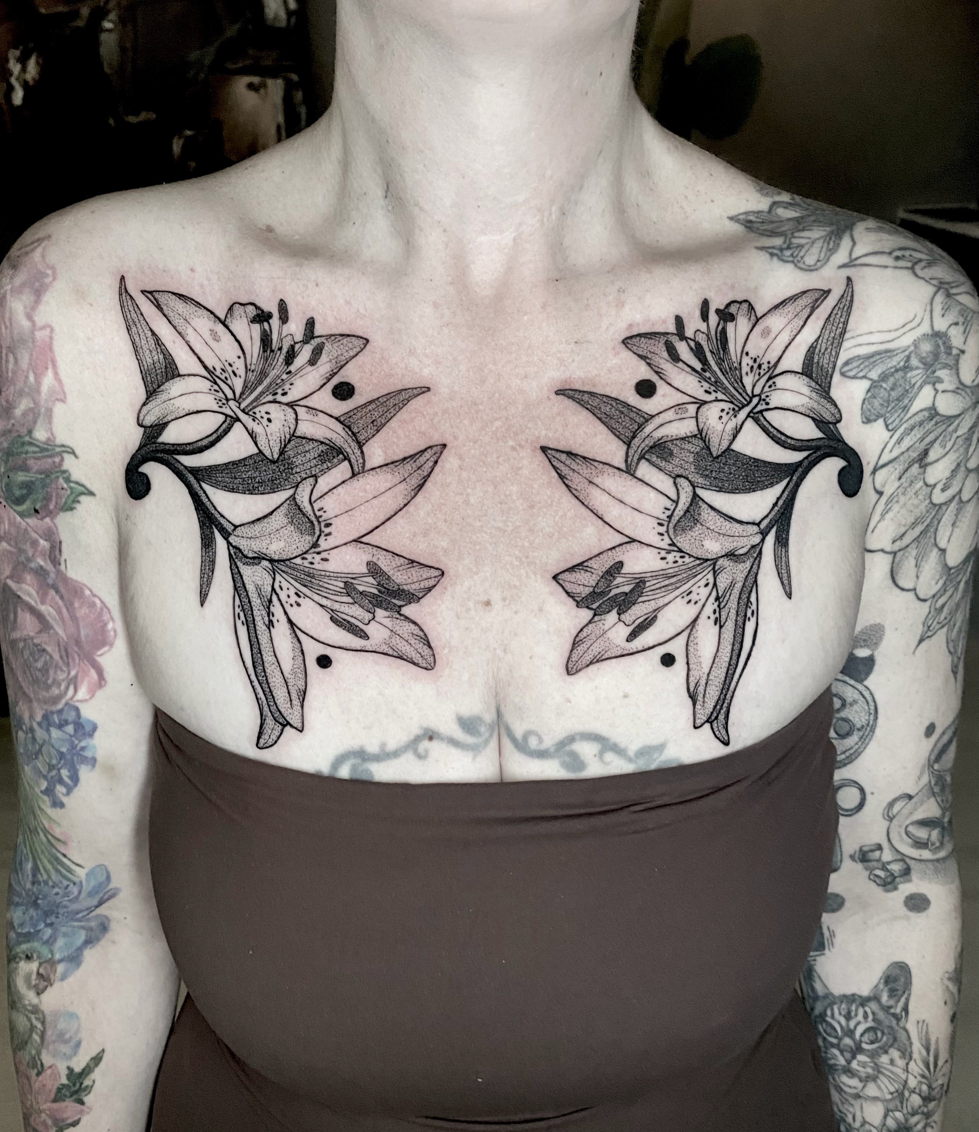 Lily flowers dotwork tattoo on the chest by Rowan Starr
