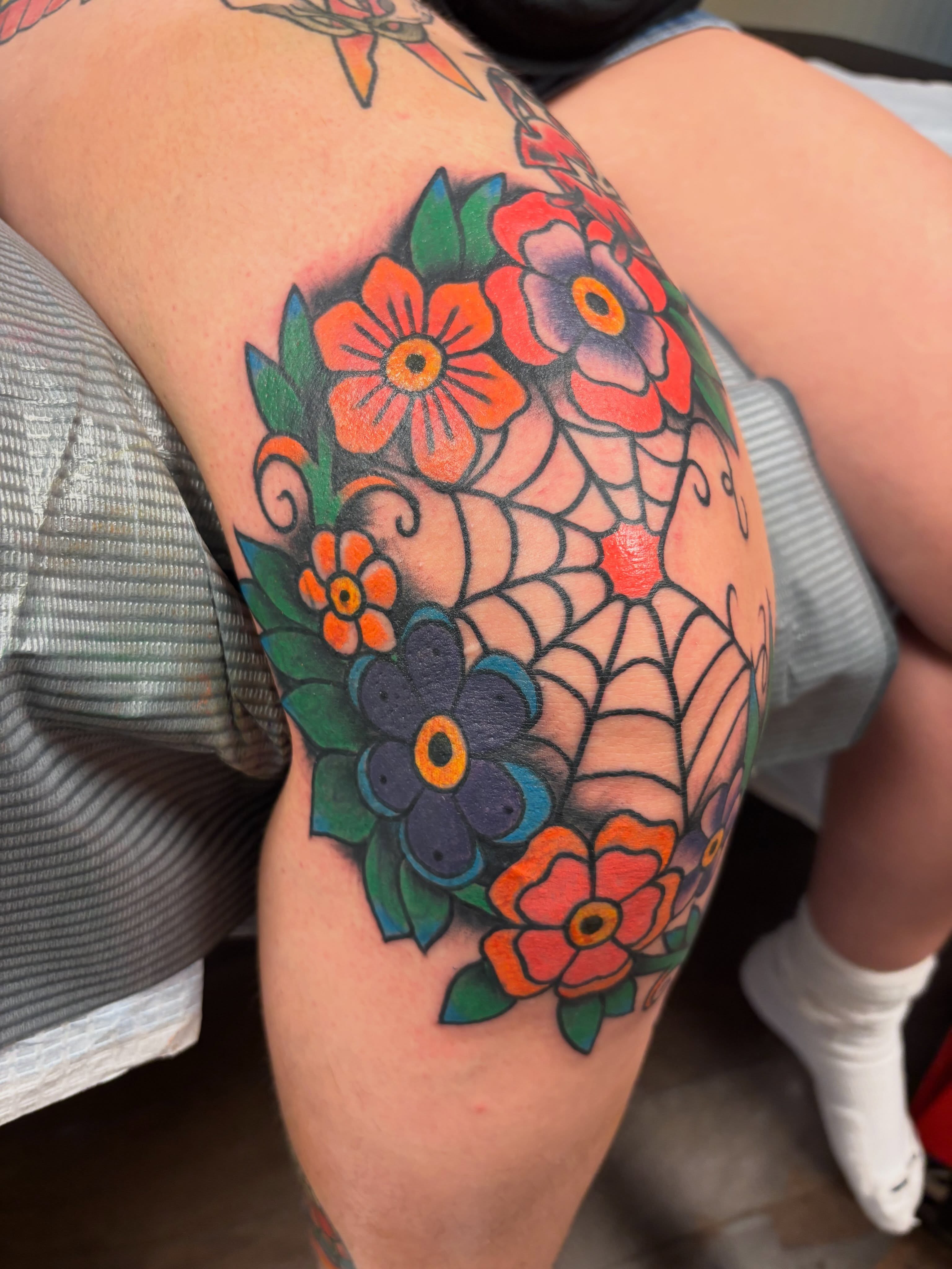 Floral bouquet American traditional tattoo on the thigh by Alex Green, Nashville, Tennessee