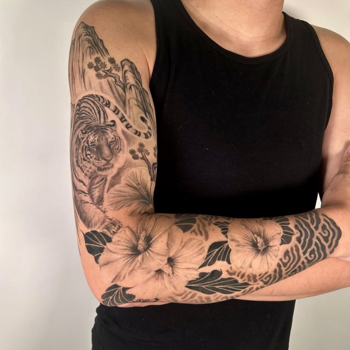Tiger and flowers realism tattoo on the forearm by Longtea
