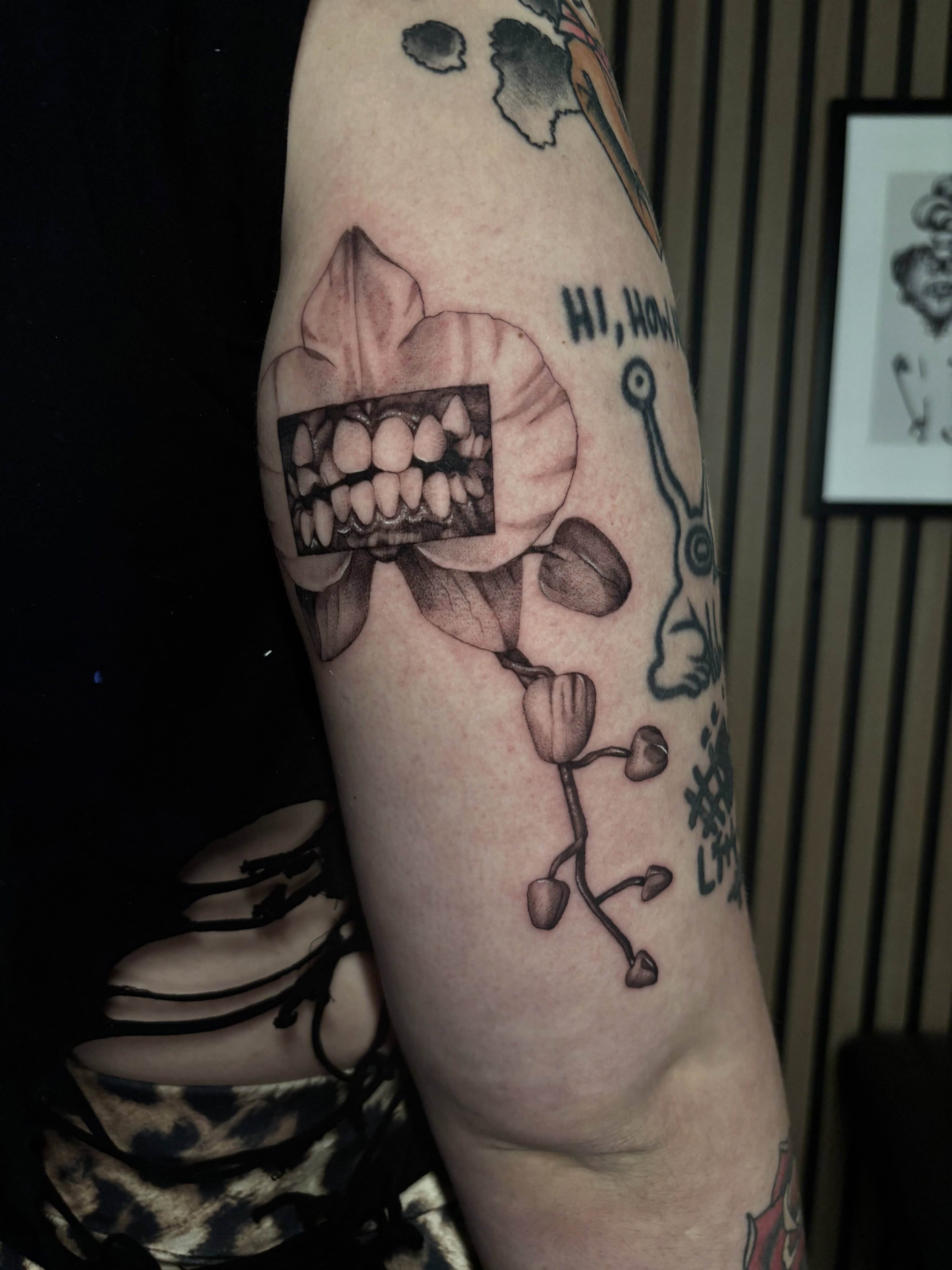 Tooth and flower black and grey tattoo on the forearm by Zilla - Tattoo Artist