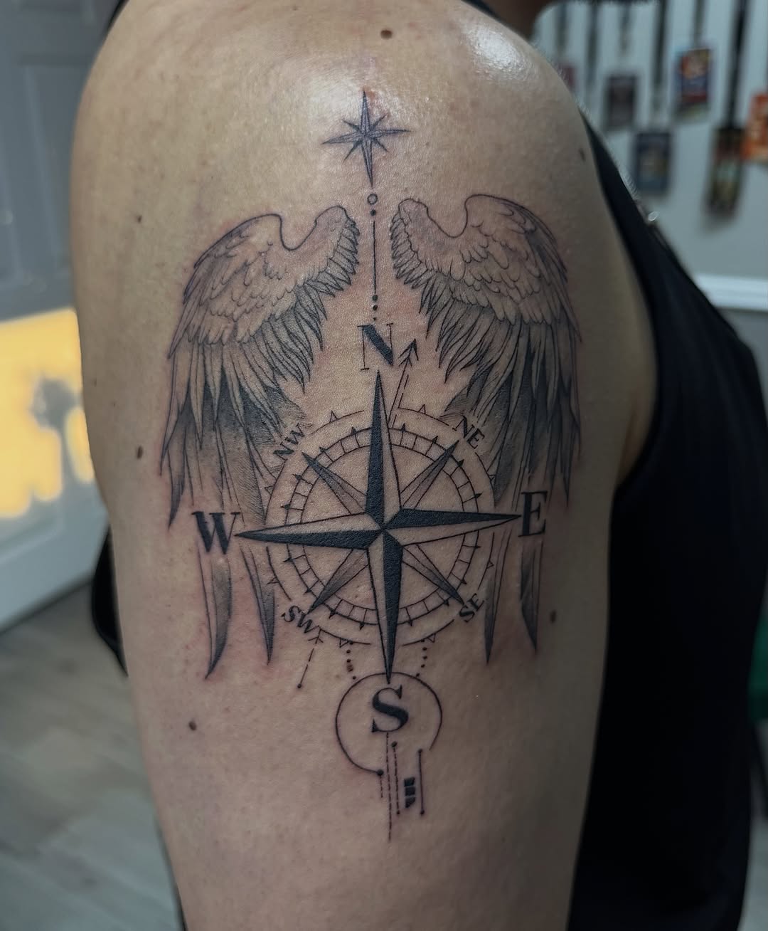 Compass with wings black and grey tattoo on the shoulder by Mo Dinero🎰