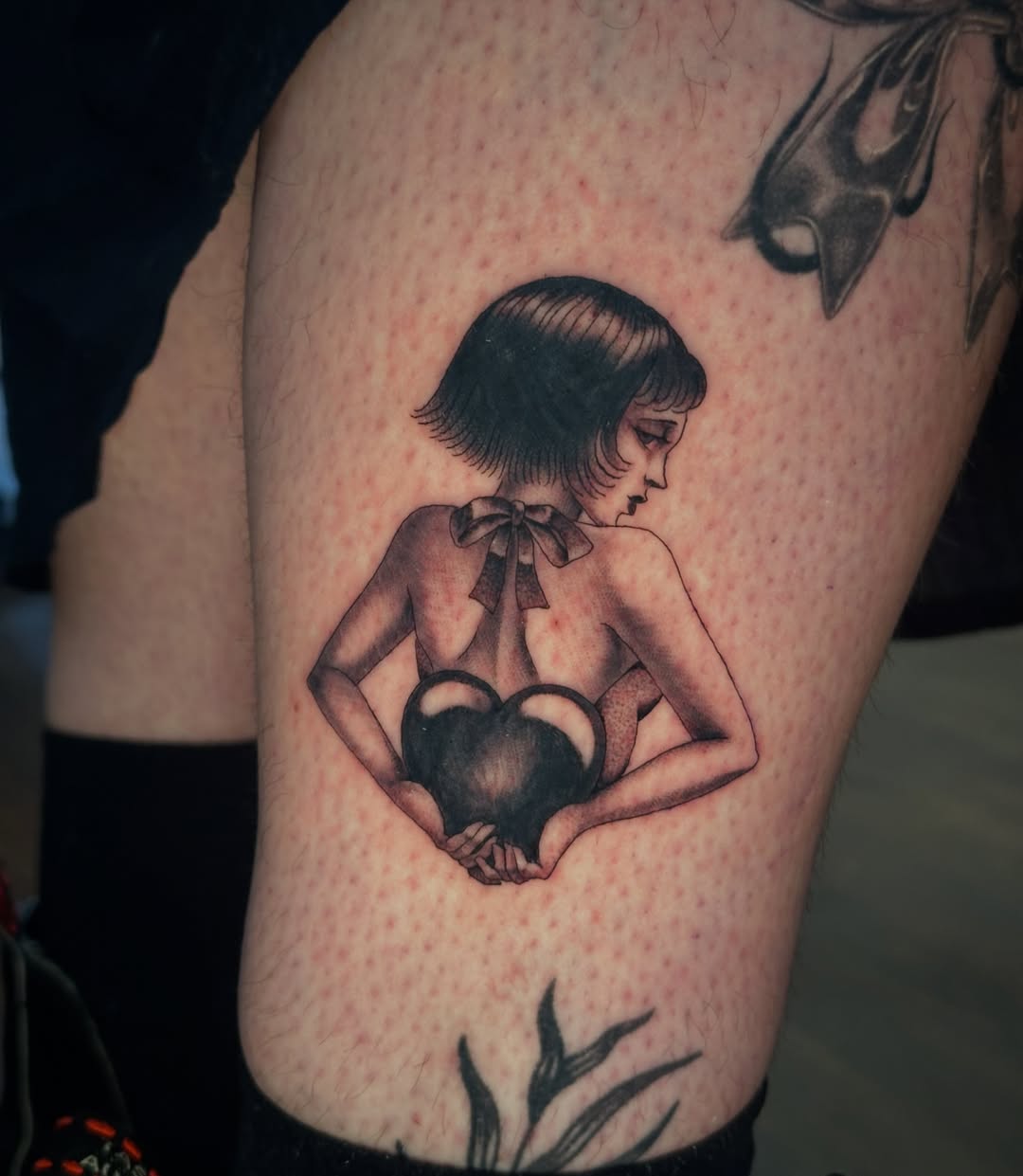 Nurse holding heart black and grey tattoo on the forearm by Bree Lin