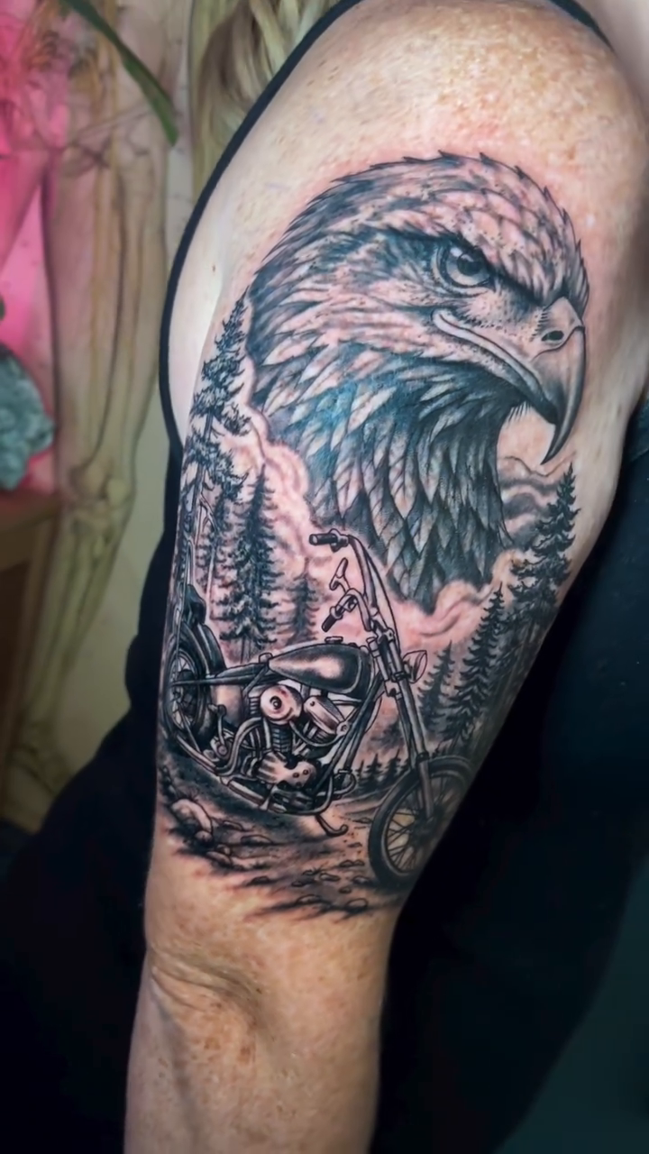 Eagle and motorcycle in a forest realism tattoo by Dev Z