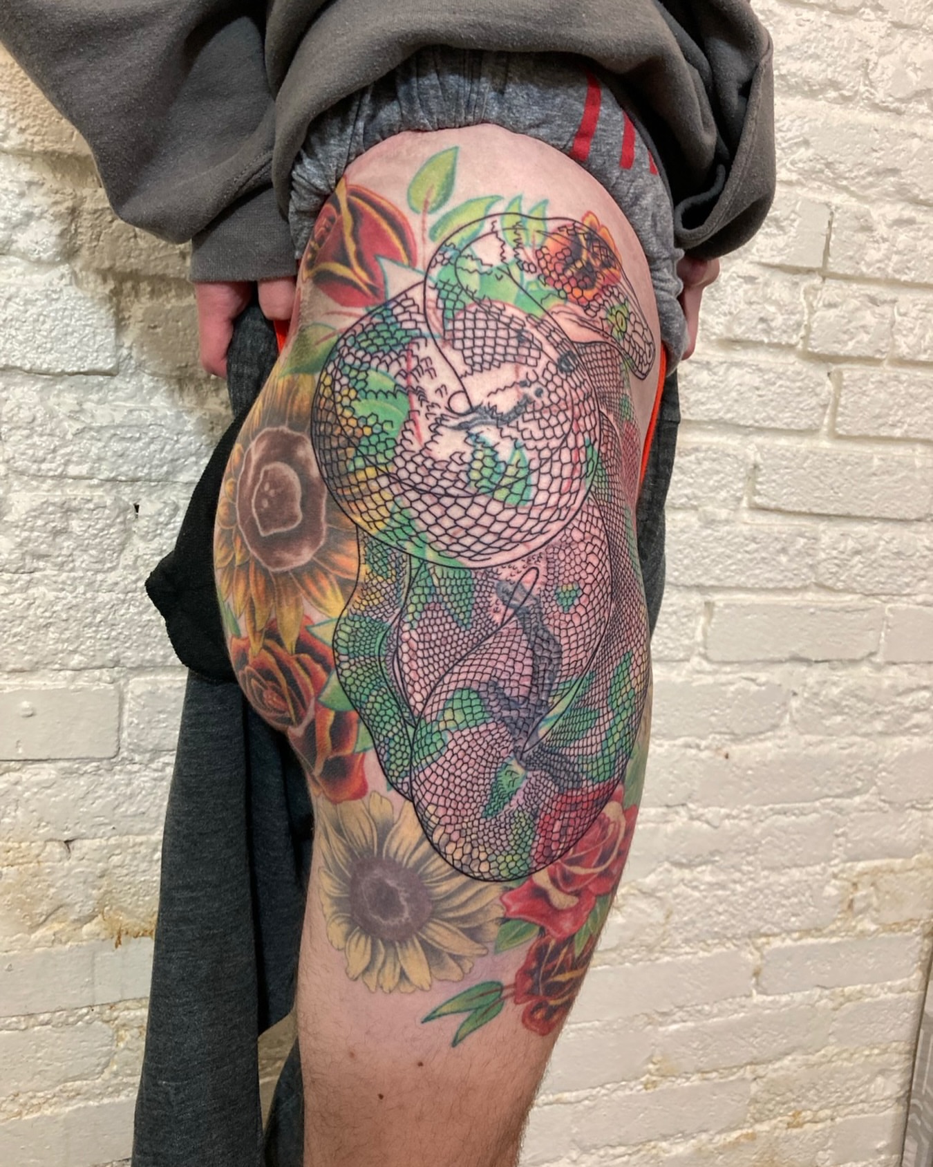 Dragon and flowers American traditional tattoo on the thigh by Ashley Antolin