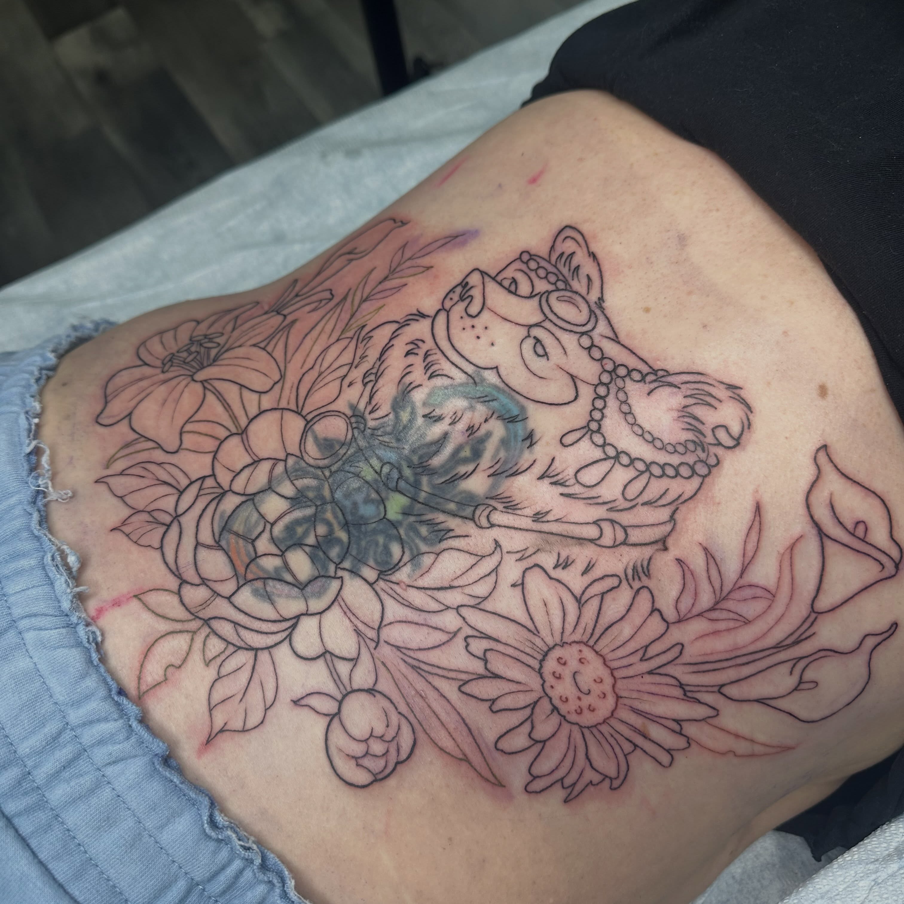 Dog with floral background black and grey tattoo on the thigh by Halle Haas