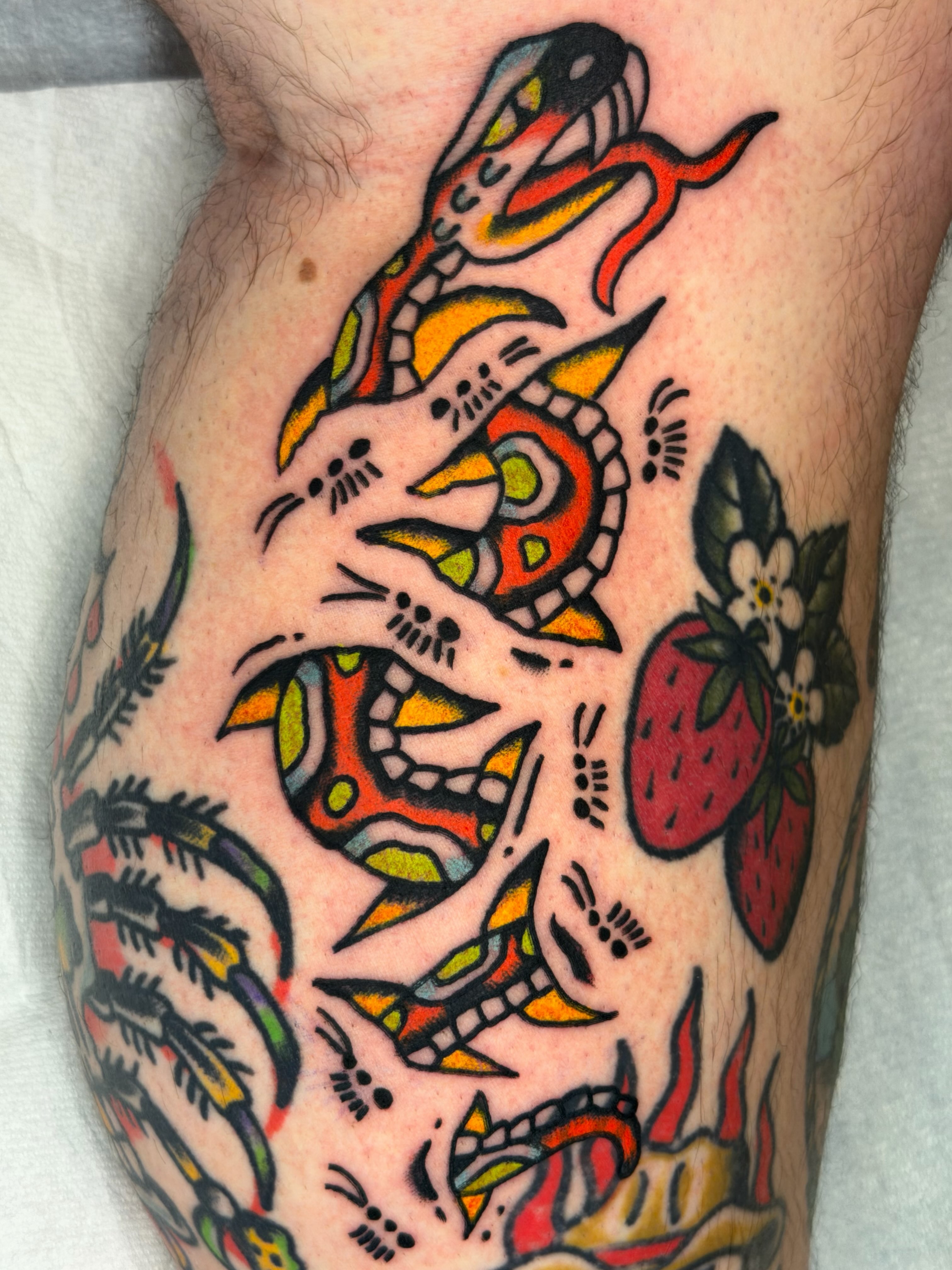 Snakes and strawberries American traditional tattoo on the thigh by Jake