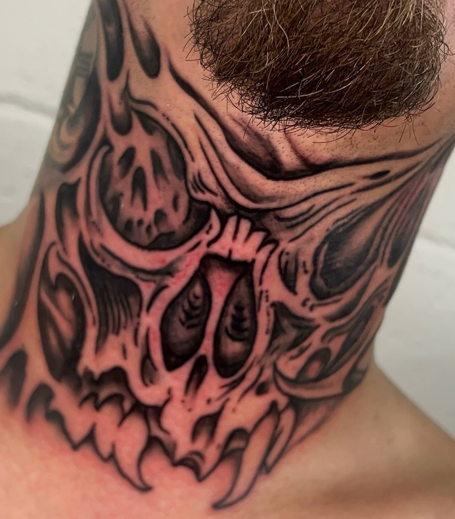 Skull black and grey tattoo on the neck by Dylan O'Quin