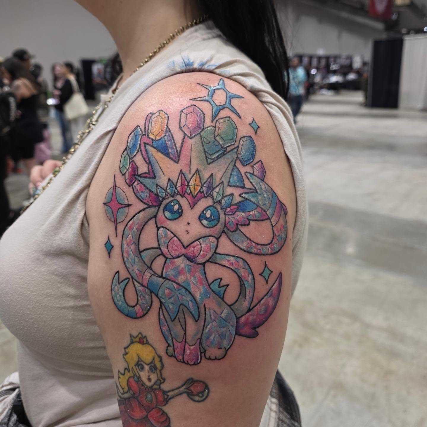 Pokémon-like creature watercolor tattoo on the shoulder by Kayla Williams