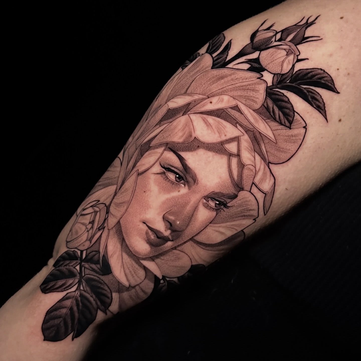 Woman with floral crown realism tattoo on the forearm by Breah Beshore Kirk